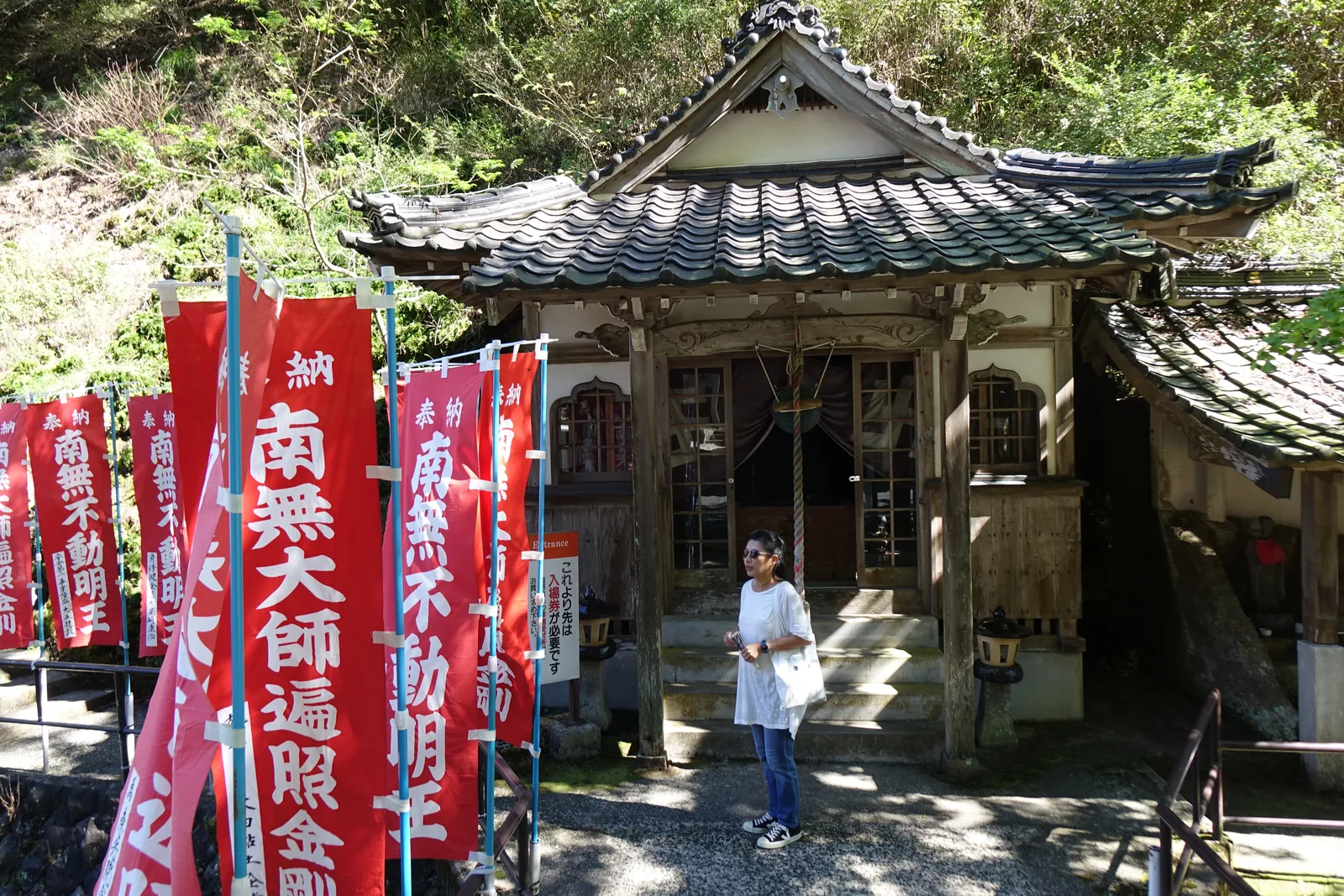 羅漢寺門前排著「南無大師遍照金剛」「南無不動明王」的紅幟，右邊立牌寫「これより先は入場券が必要です」