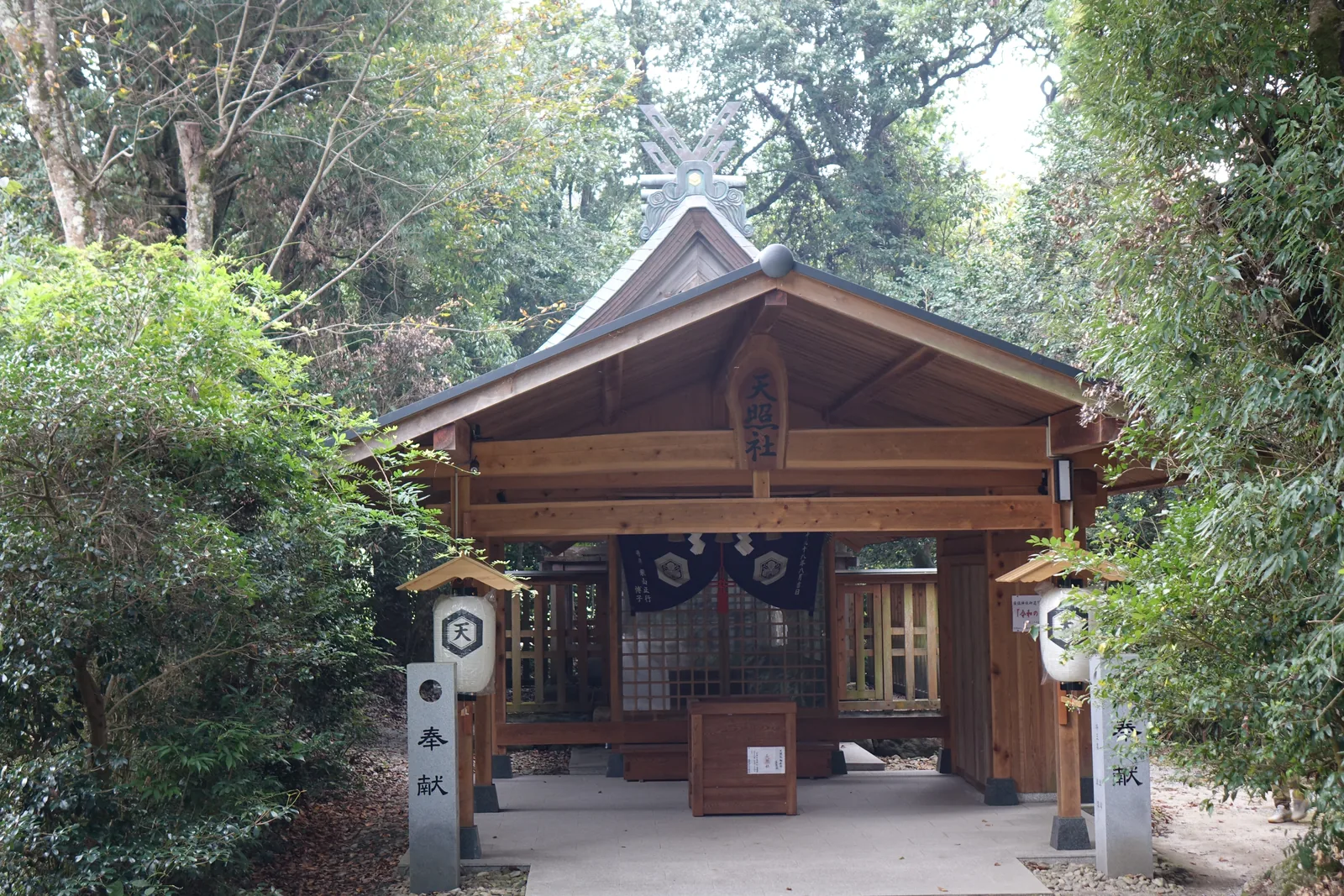 須佐神社的境內社天照社，新木材尚未曬灰，扁額寫「天照社」，脊上有千木與鰹木，燈籠寫一個「天」字