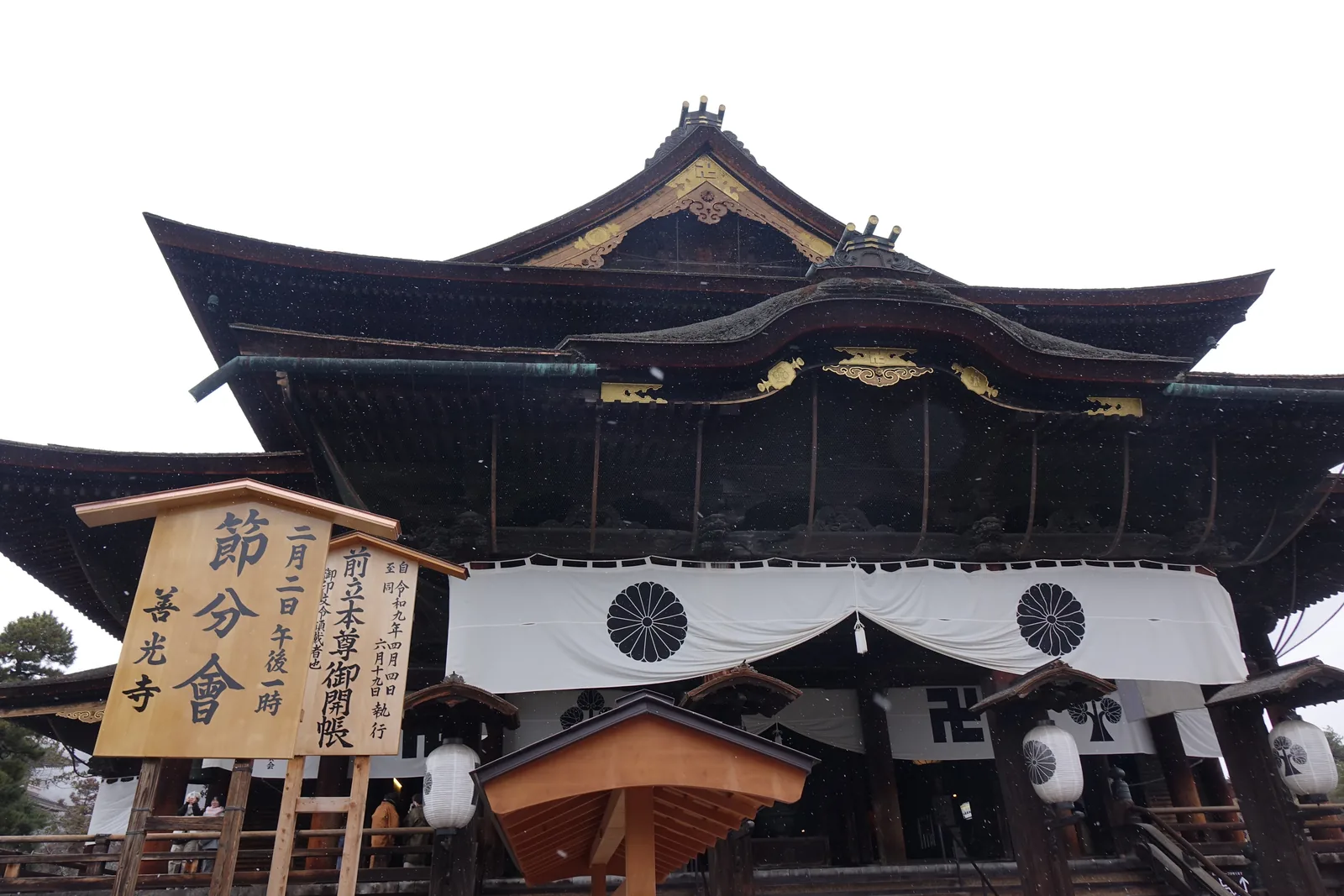 善光寺本堂正面，撞木造的 T 字形屋脊，前方立著節分會與御開帳的木札