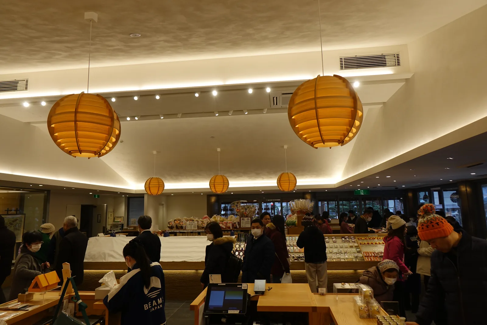 善光寺授与品所內部，橘色紙燈籠下的陳列與工作人員