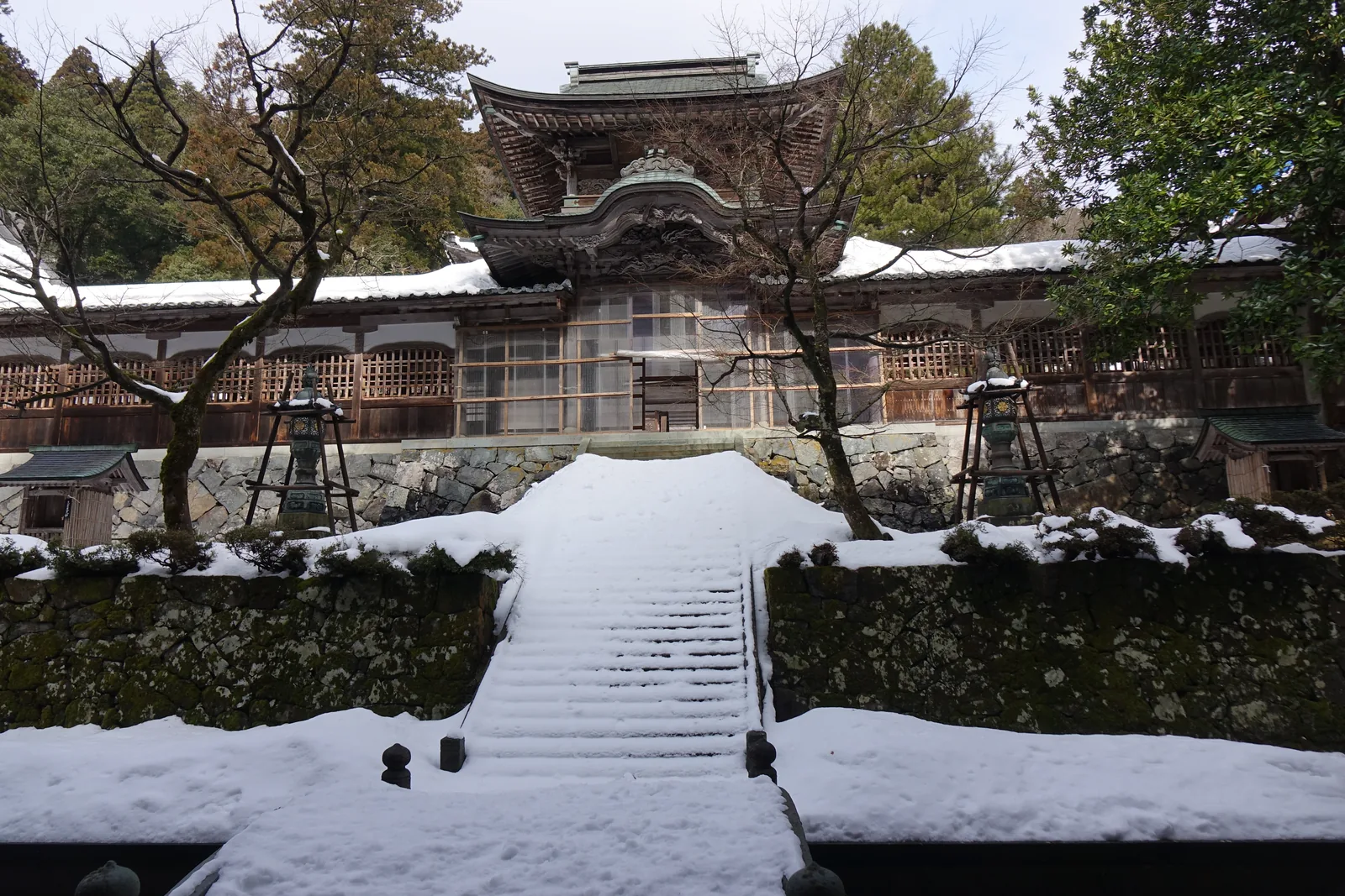 二月雪中的永平寺伽藍，石段與庭園被壓成白色，屋脊的線在杉木之間浮出來