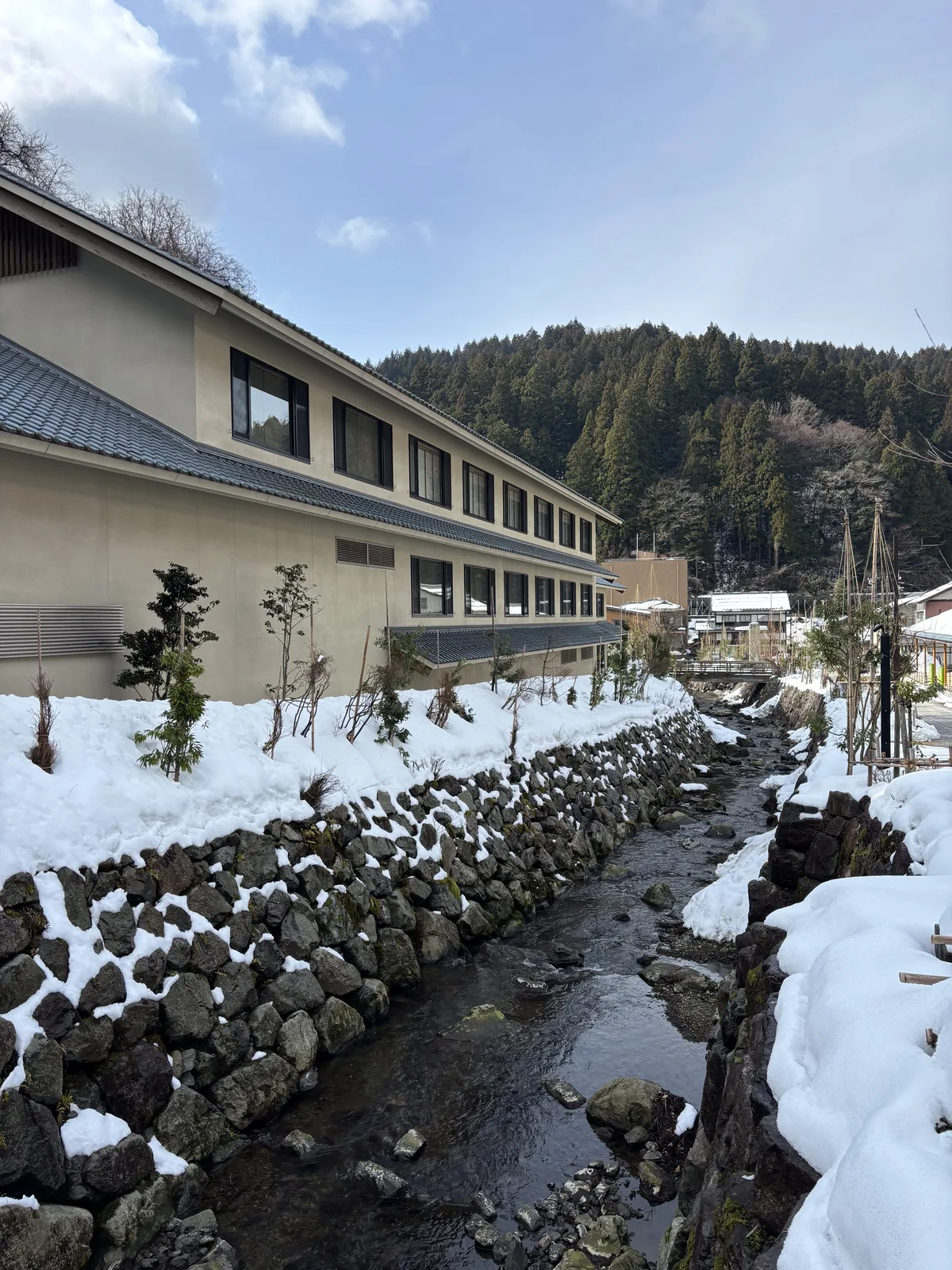 永平寺川的石積護岸，積雪壓在石縫上，對岸是門前的建物