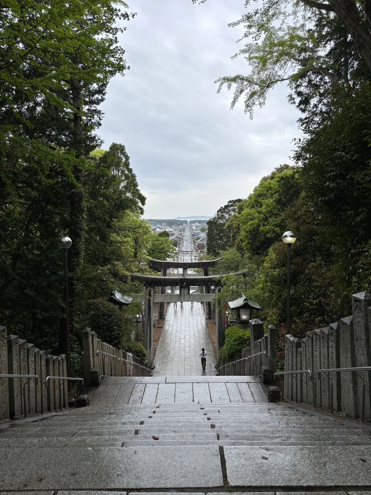 從男坂頂端回望，石段、鳥居與門前町的直線街道一路通到海