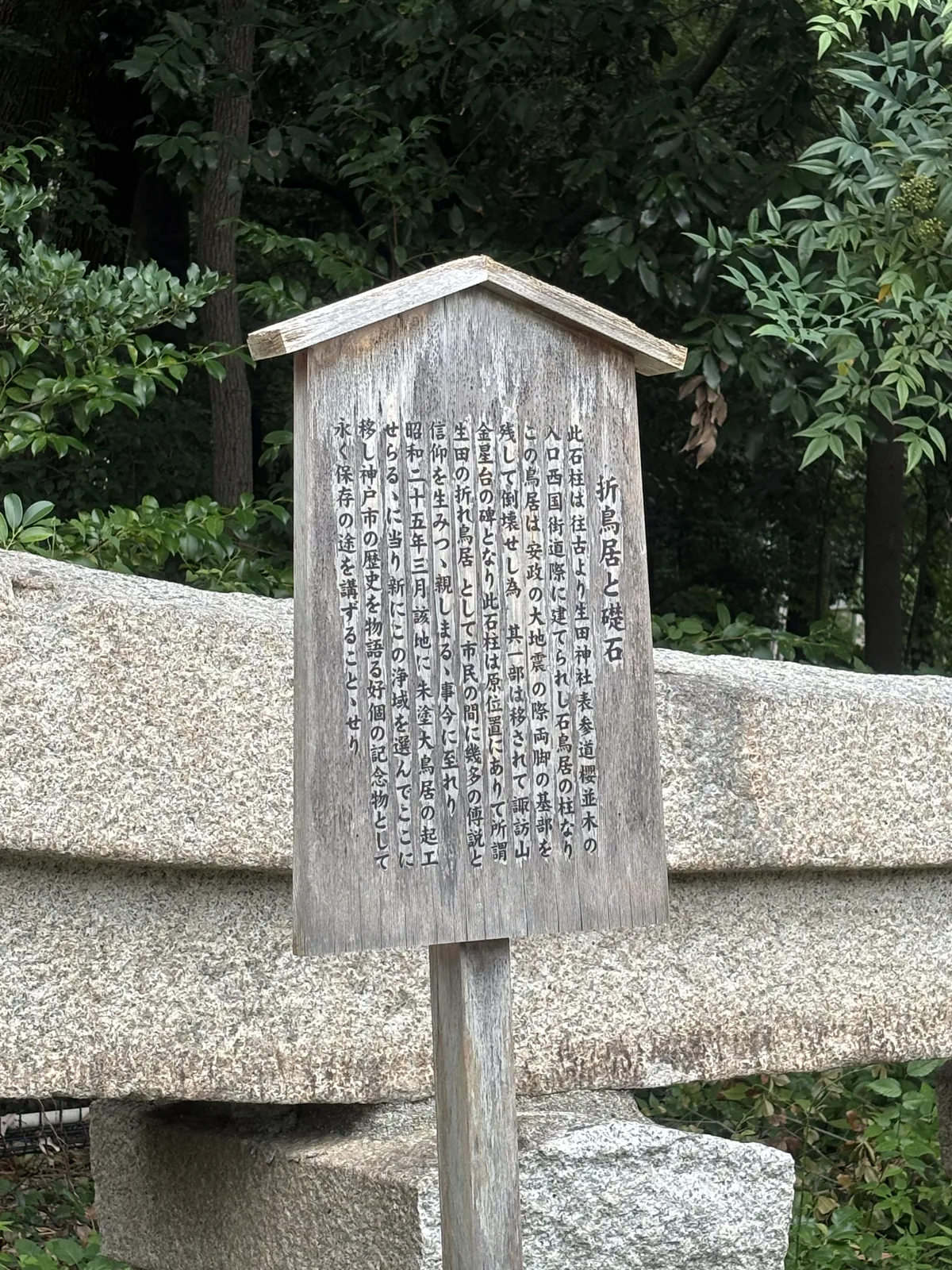 木製說明板題「折鳥居と礎石」，背後橫躺的花崗岩就是那根柱。板上寫：此石柱原是立在表參道櫻並木入口、西國街道旁的石鳥居的柱；安政的大地震時鳥居只剩兩腳基部、其餘倒壞，一部分被移到諏訪山金星台成為碑；昭和二十五年三月因該地起工建朱塗大鳥居，遷到森中這片淨域永久保存。