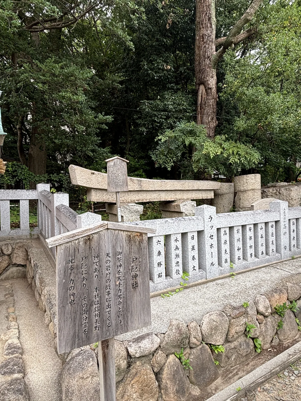 石鳥居與石造玉垣圍出的境內社。木牌寫祭神是天手力男命，天岩戶故事裡的力神，本社在信州長野的戶隱，此處祀其分靈。玉垣的每根石柱上刻著奉納者——讀得出神戶在地的字號與人名。