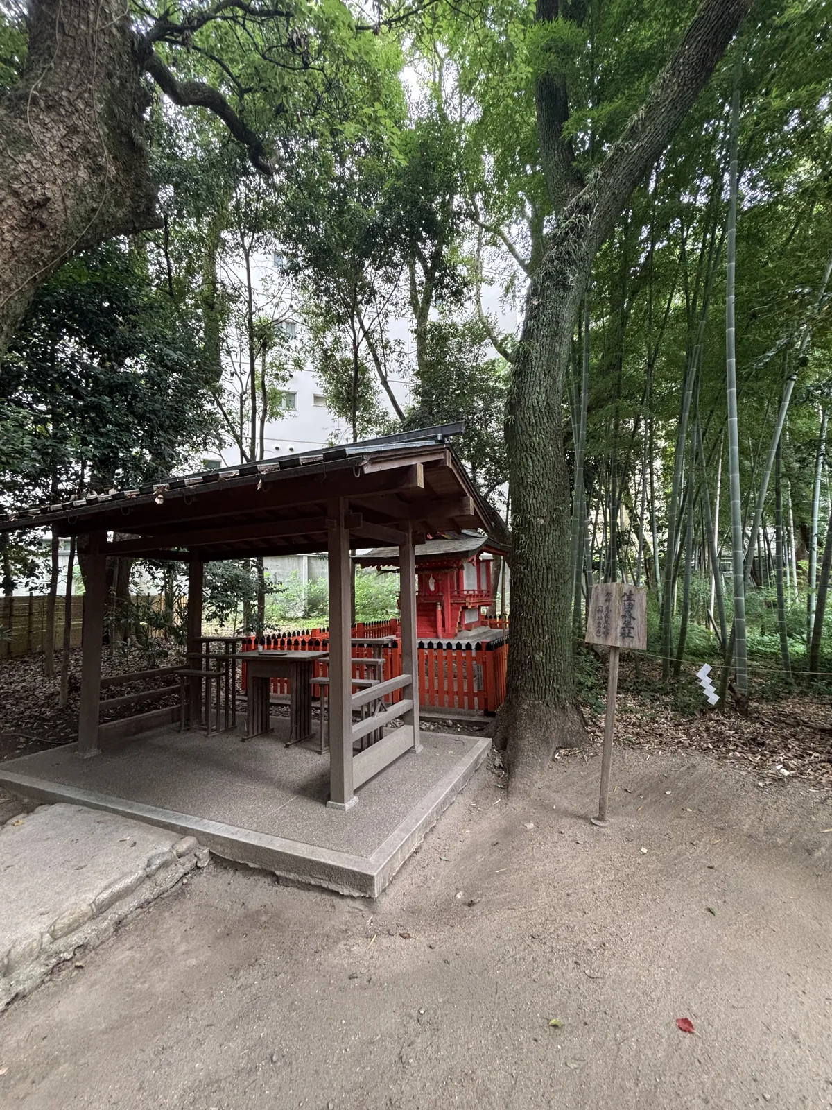 竹林中的境內社，朱塗小社殿前罩一座木造的覆屋。前景的木牌寫「生田森坐社／祭神　息長足姫命（神功皇后）」。周圍以繩與紙垂圍出範圍，地面全是竹葉。