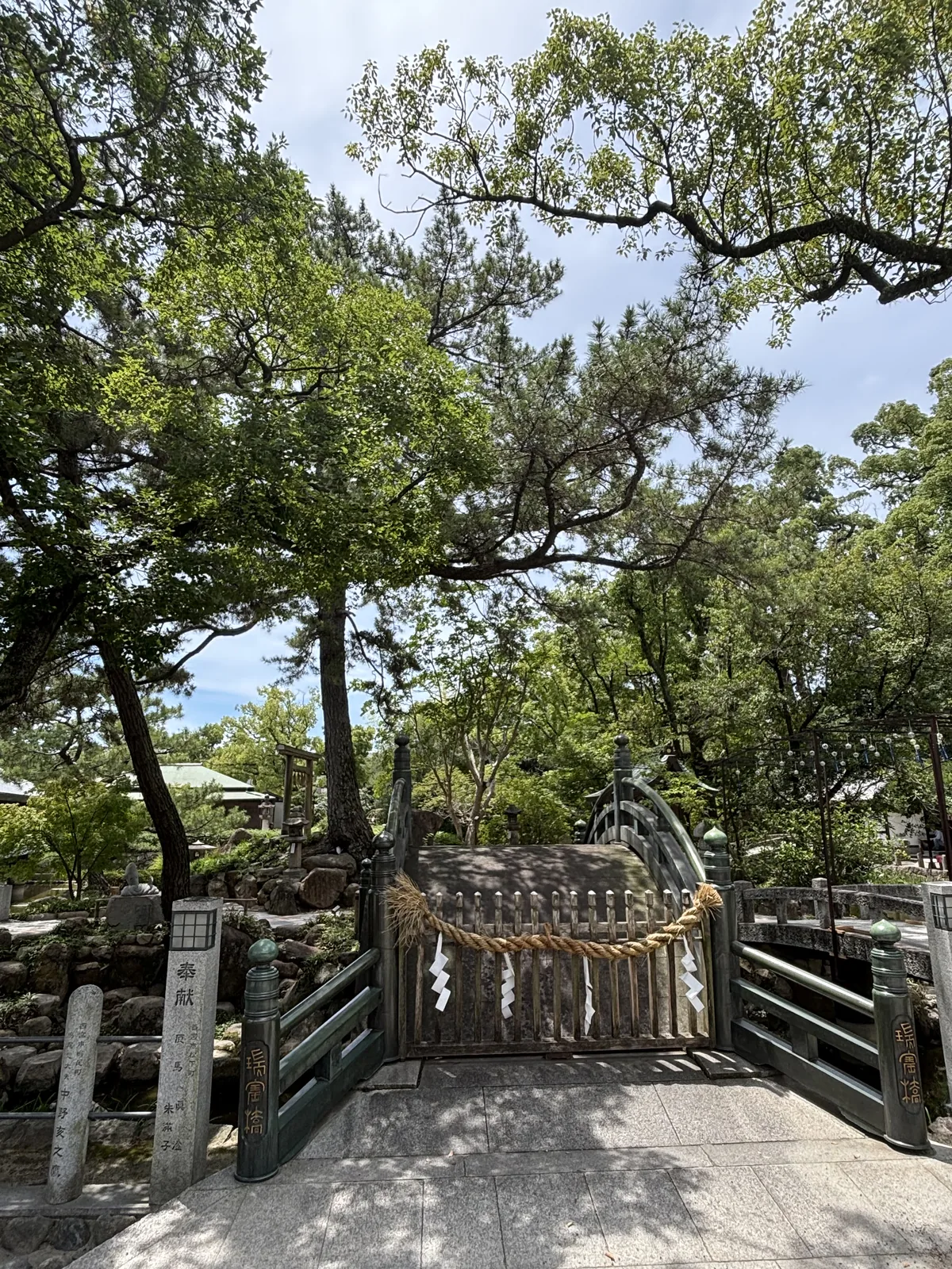 石造的太鼓橋（弧形反橋），青銅欄干，橋面橫結一條注連繩與四張紙垂。橋頭石柱刻「瑞寶橋」，對面一柱刻「奉獻」與捐納者名。橋通往神池中的島。六甲山產花崗岩，明治四十年白鷹酒造初代辰馬悅叟奉納，大正十一年由二代改修完成。