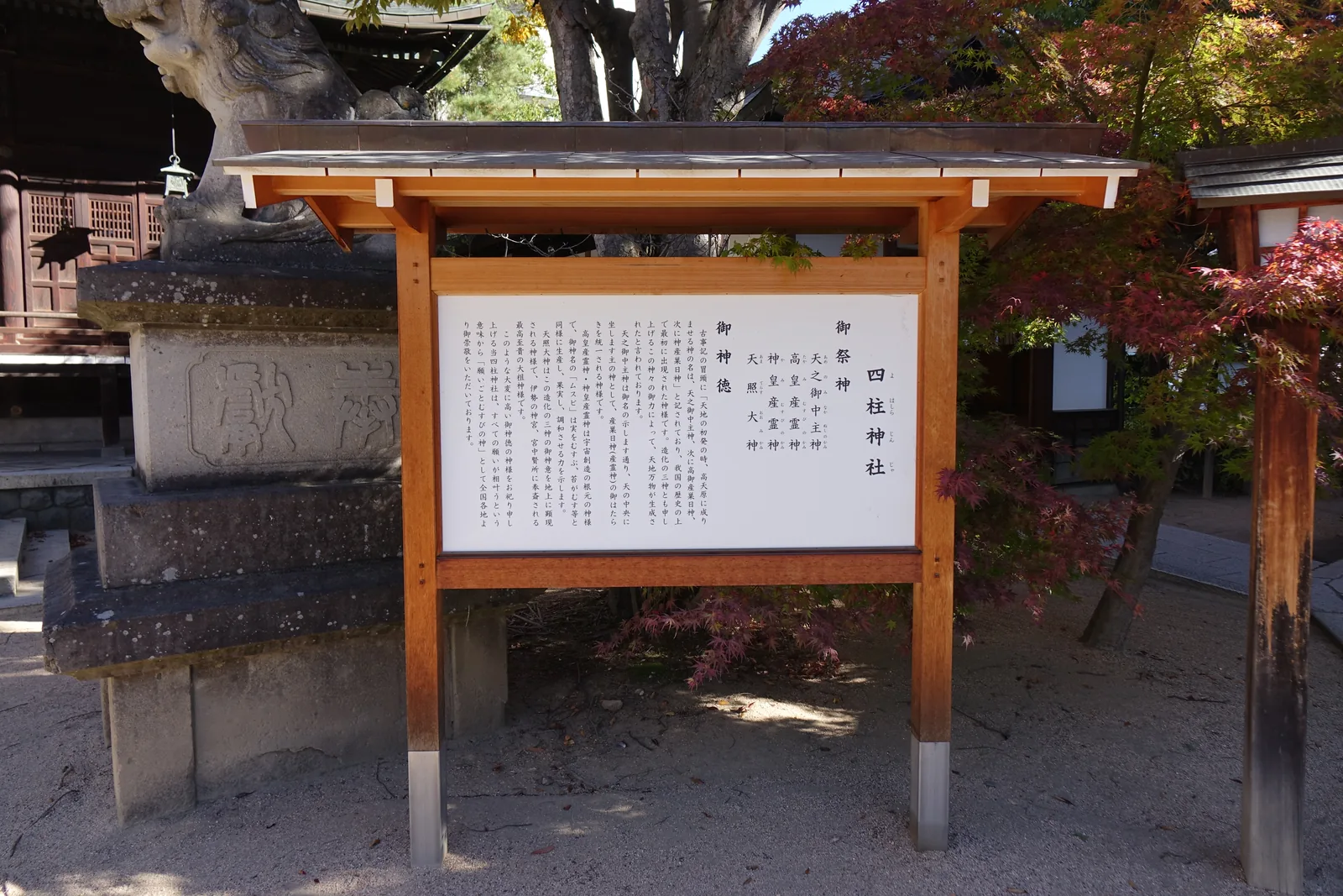木框加小屋根的白色說明板。上半列出御祭神四柱：天之御中主神、高皇產靈神、神皇產靈神、天照大神。下半「御神徳」抄了《古事記》開頭那一句，並解釋「產靈」是結出果實的生成之力，末尾說明因此被稱為「願いごとむすびの神」，一切願望都能相結相成的神。板子左後方是狛犬的台座，上面刻著一個大大的「獻」字。
