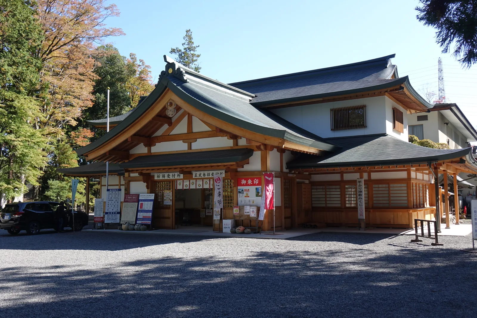 這一棟的屋頂是入母屋造（いりもやづくり，即歇山頂）加向拜，屋面是暗綠的金屬板，木構部分同樣是素木。窗口一列並排，上方橫掛「祈禱受付所」「正式參拜受付」的木牌。