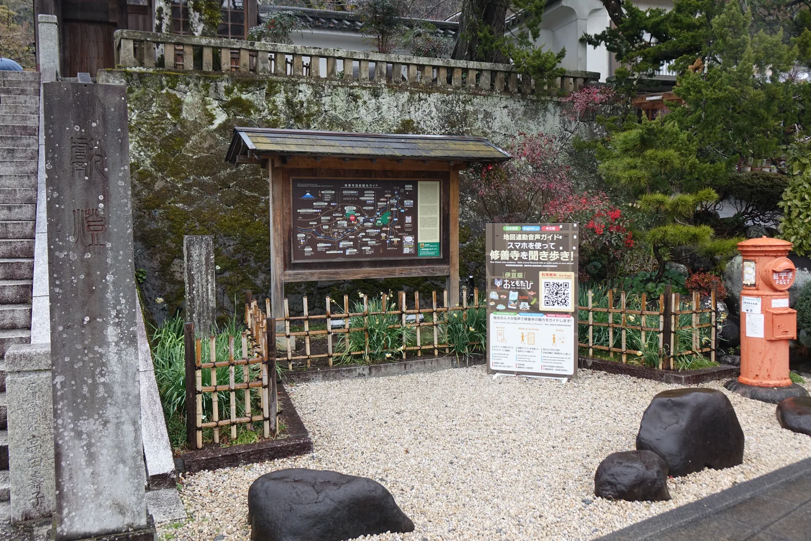 修禪寺山門前的石階、木造觀光案內板與一支舊式圓筒郵筒