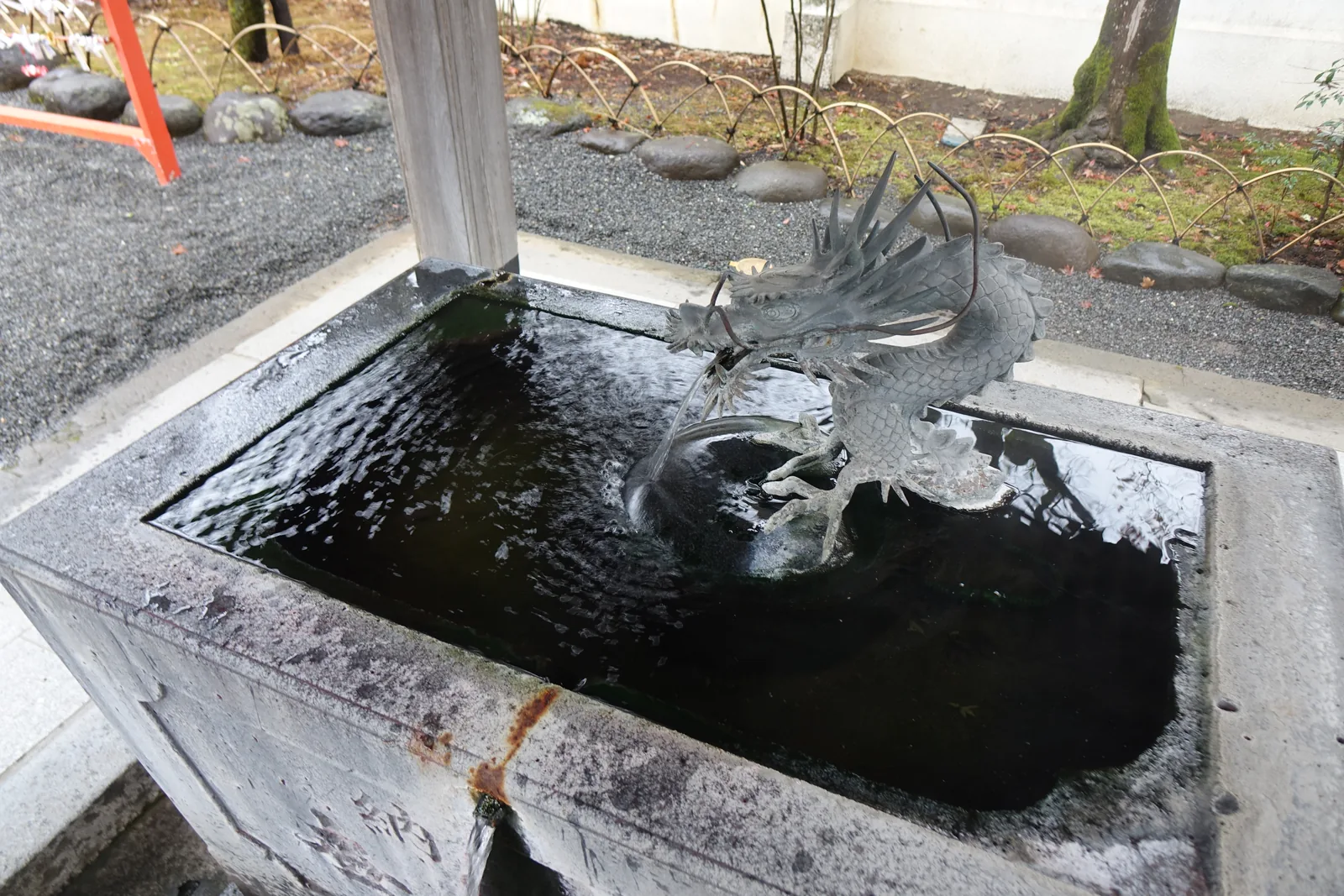 青銅龍口流出的溫泉，石槽邊緣附著白色析出物
