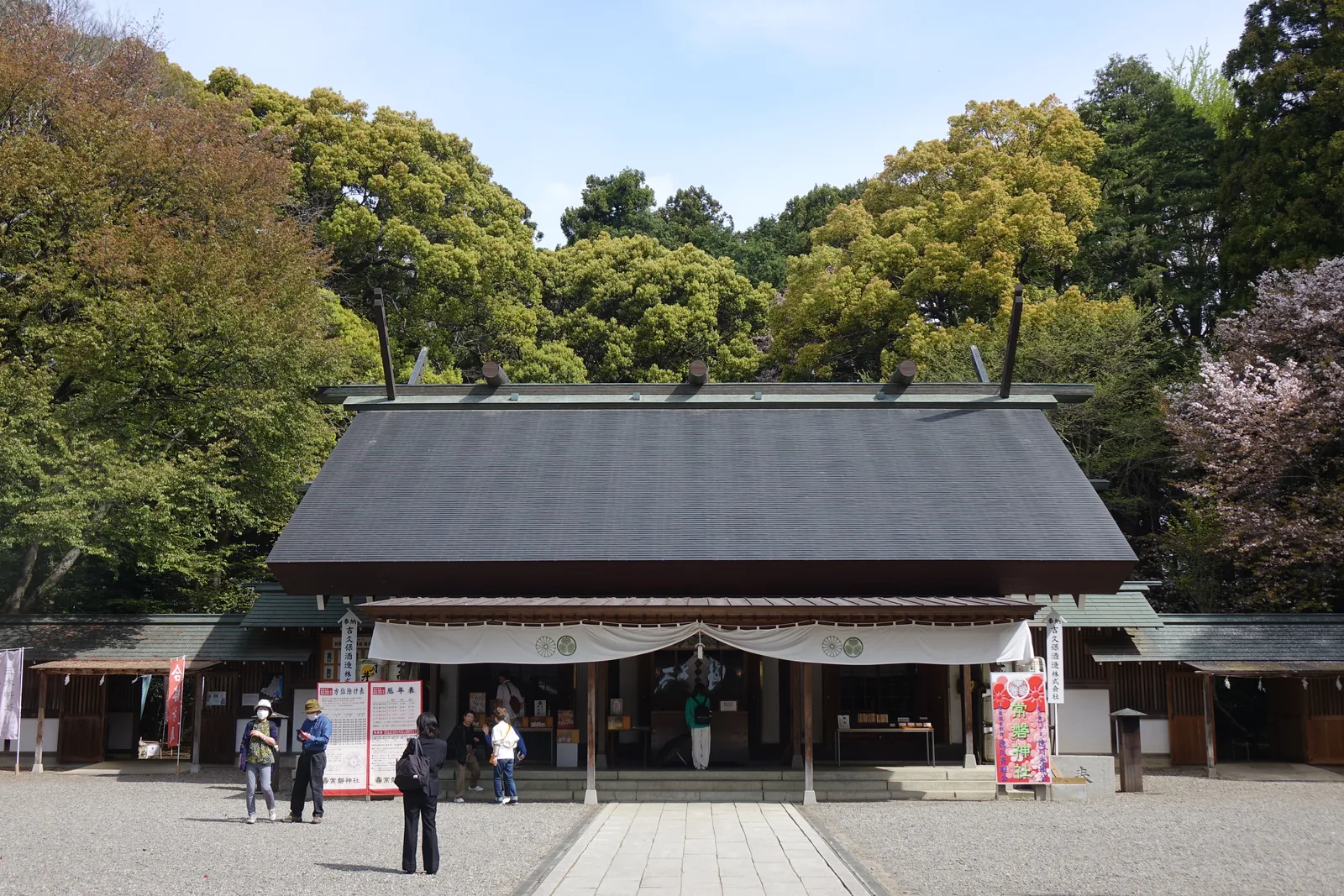 神明造，屋頂是泛青綠的銅板，脊上排著鰹木、兩端伸出千木。正面掛白幕，幕上是三葉葵。左右兩側是授与所與掲示板。這一棟是昭和三十三年用全國崇敬者的浄財重建的——昭和二十年八月的水戶空襲把境內幾乎所有建物都燒掉了。