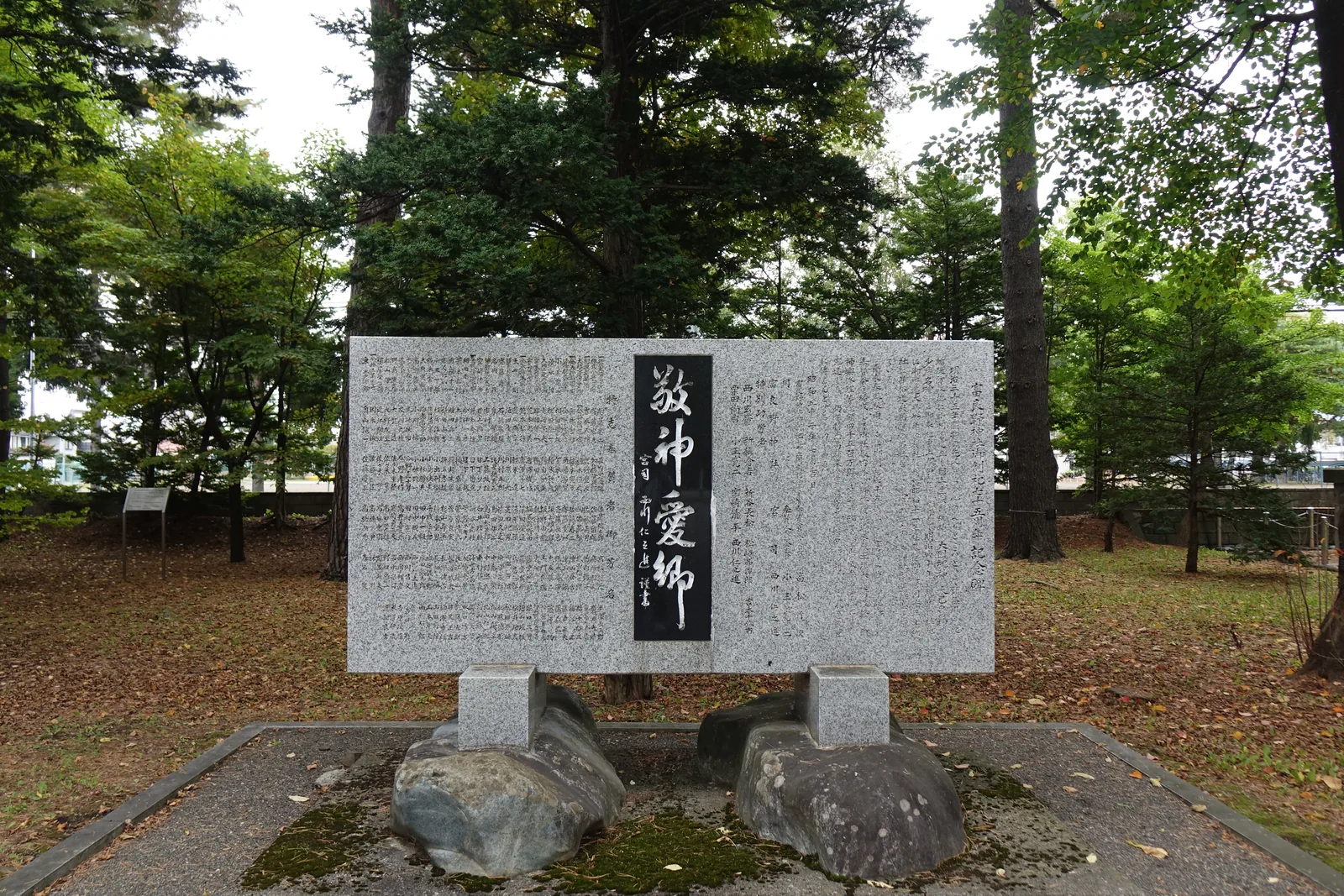 富良野神社境內的「敬神愛郷」石碑，碑額是黑石嵌板，兩側刻滿奉賛者姓名