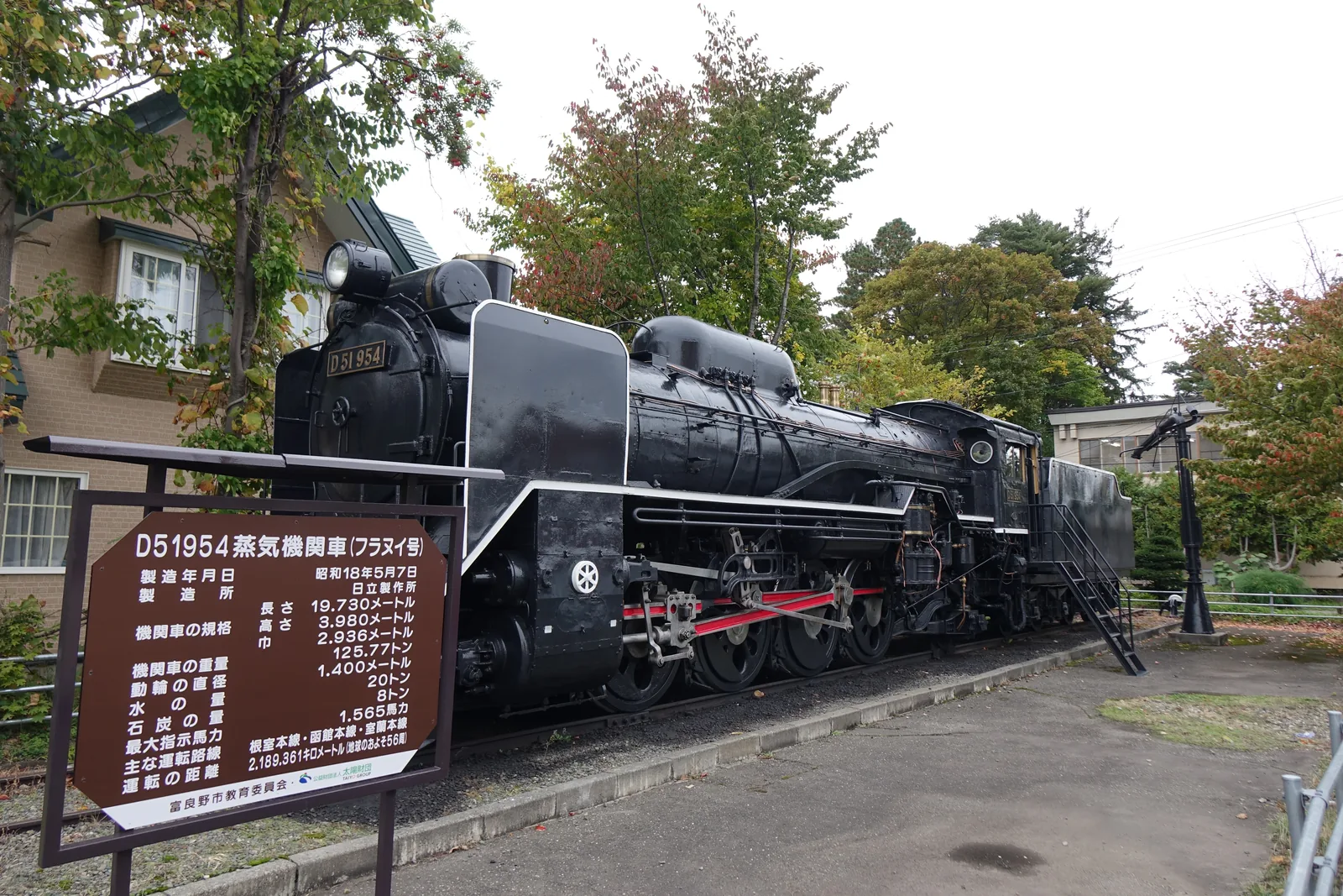 富良野市複合廳舍旁保存的蒸汽機關車 D51 954「フラヌイ號」，車頭前立著褐色的說明板