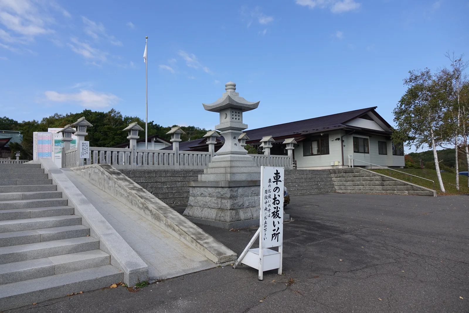 樽前山神社的寬石段與白色石造高欄，段頂是朱漆的社殿，右側是社務所