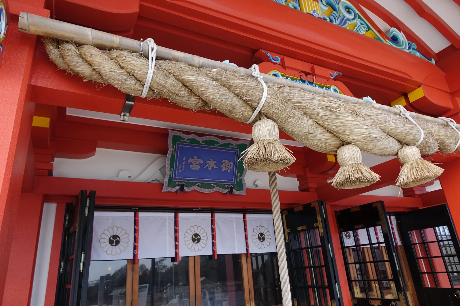 樽前山神社拜殿向拜下的大注連繩，白色的紙垂與藁束垂下，綠底金字的扁額寫著「御本宮」