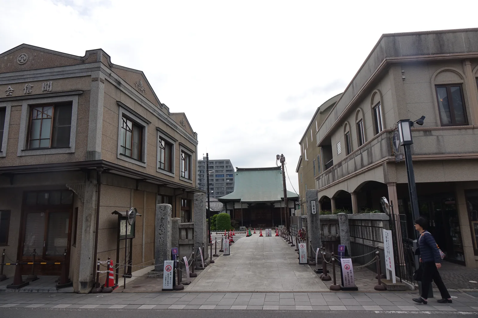 兩棟灰褐色的洋風二層樓夾出一條石板參道，左棟山牆上橫書「聞信會」。參道兩側各立一支石柱與一排繫著鐵鍊的短柱，底端是一棟綠色銅板葺的入母屋造大堂。右棟是拱窗的三層建物。路面上擺著交通錐與禁止事項的立牌。