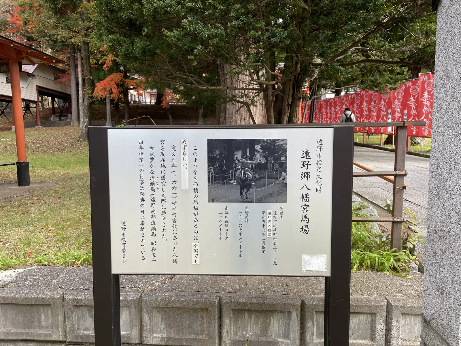 遠野市指定文化財「遠野鄉八幡宮馬場」，昭和五十六年二月指定。板上寫明馬場面積一萬零一百零七平方公尺、南端直線跑道兩百一十八公尺，並記：寬文元年（一六六一）自松崎町宮代遷宮至現址時造營，「這樣大面積的馬場，全國也少見」。附的黑白照片是流鏑馬奉納的場面。