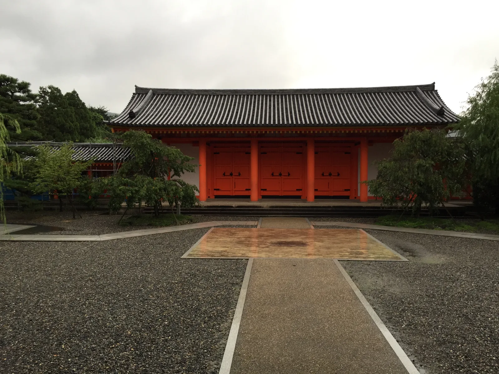 境內東側的朱漆大門：五開間、中央三間各裝一對黑鐵件的板門，兩端是白灰牆，上頭是本瓦鋪的屋頂；門前一條鋪石的路，路中央嵌著一塊被雨打得發亮的大石板，兩側是濕的碎石地與松