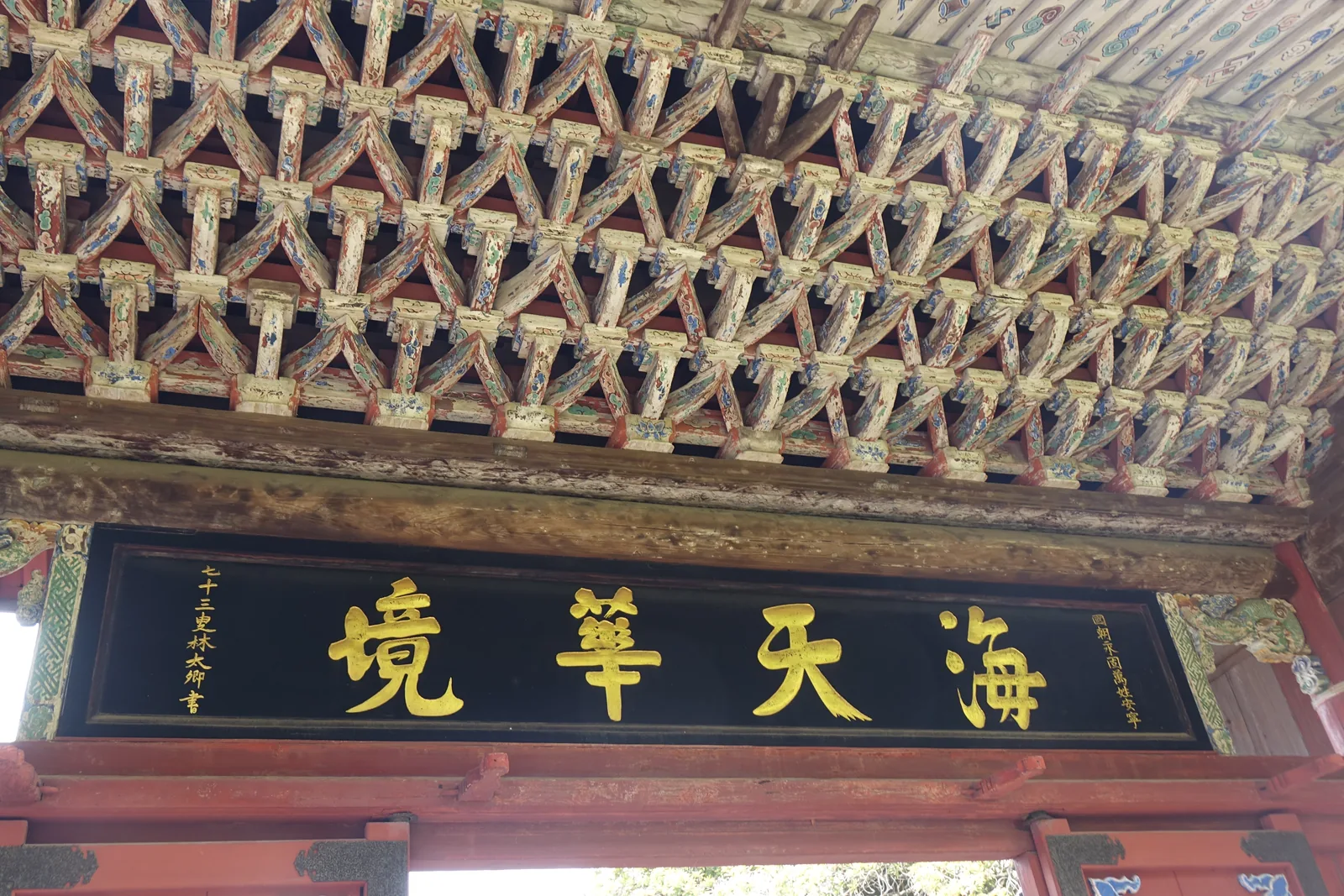 崇福寺第一峰門簷下密實的斗栱，下方掛著黑底金字的「海天華境」扁額