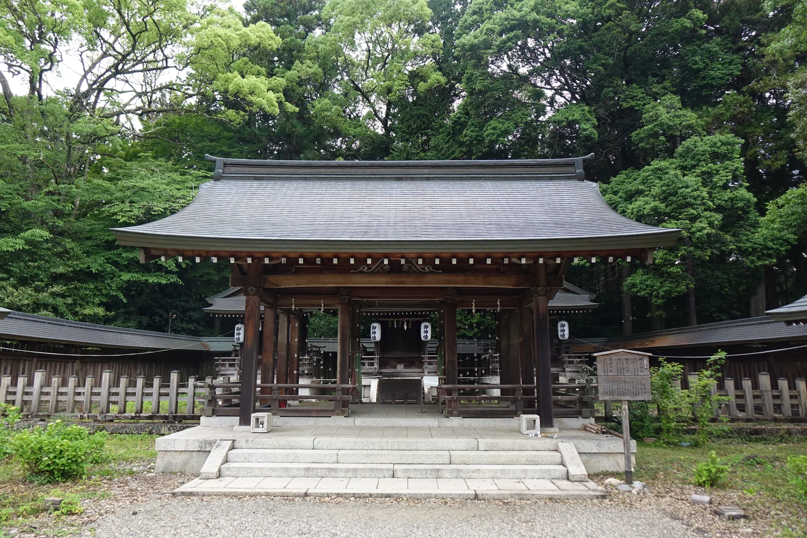 吉野神宮攝社三社前的拜所，柱間開敞沒有牆，軒下掛著四張寫御神燈的白提燈，兩側伸出瑞垣