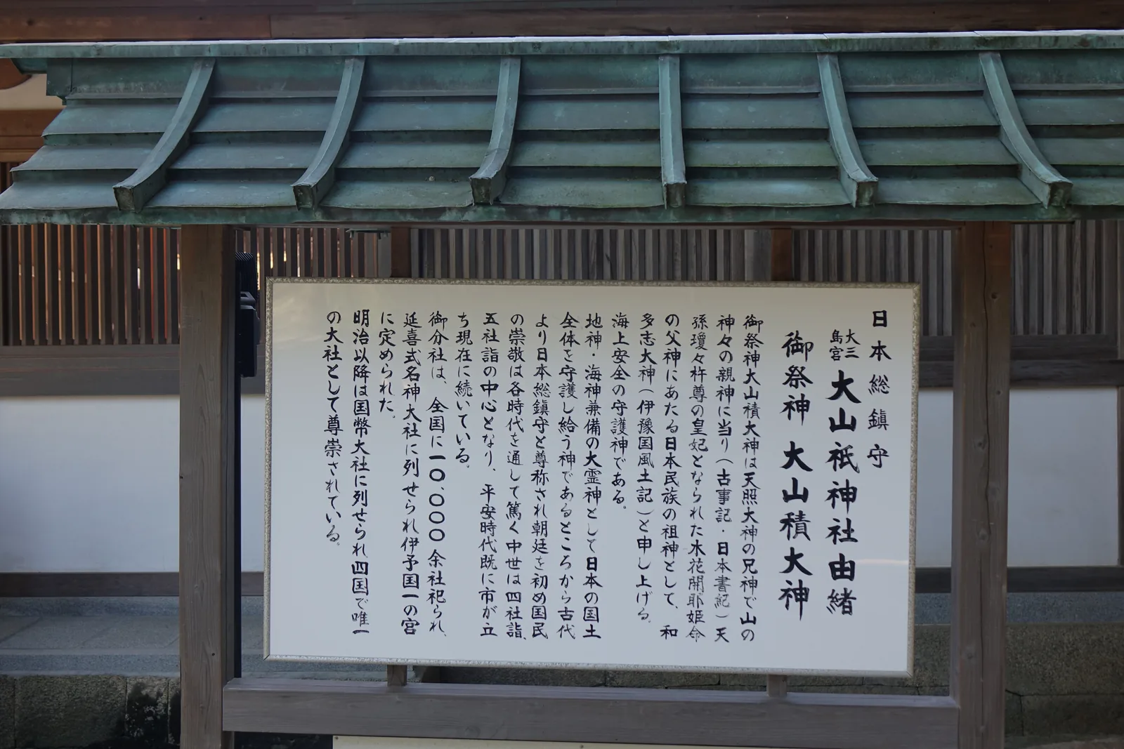 大山祇神社的由緒板，銅板葺覆屋下的白底墨書，標題寫「日本總鎮守　大三島宮　大山祇神社由緒」