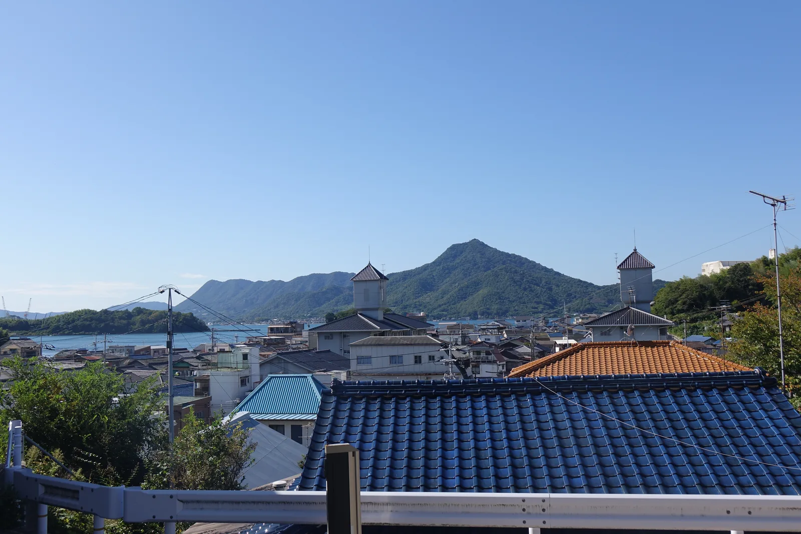 從大山神社境內往南看，屋瓦一路鋪到海邊，對岸是生名島，海峽窄得像一條河
