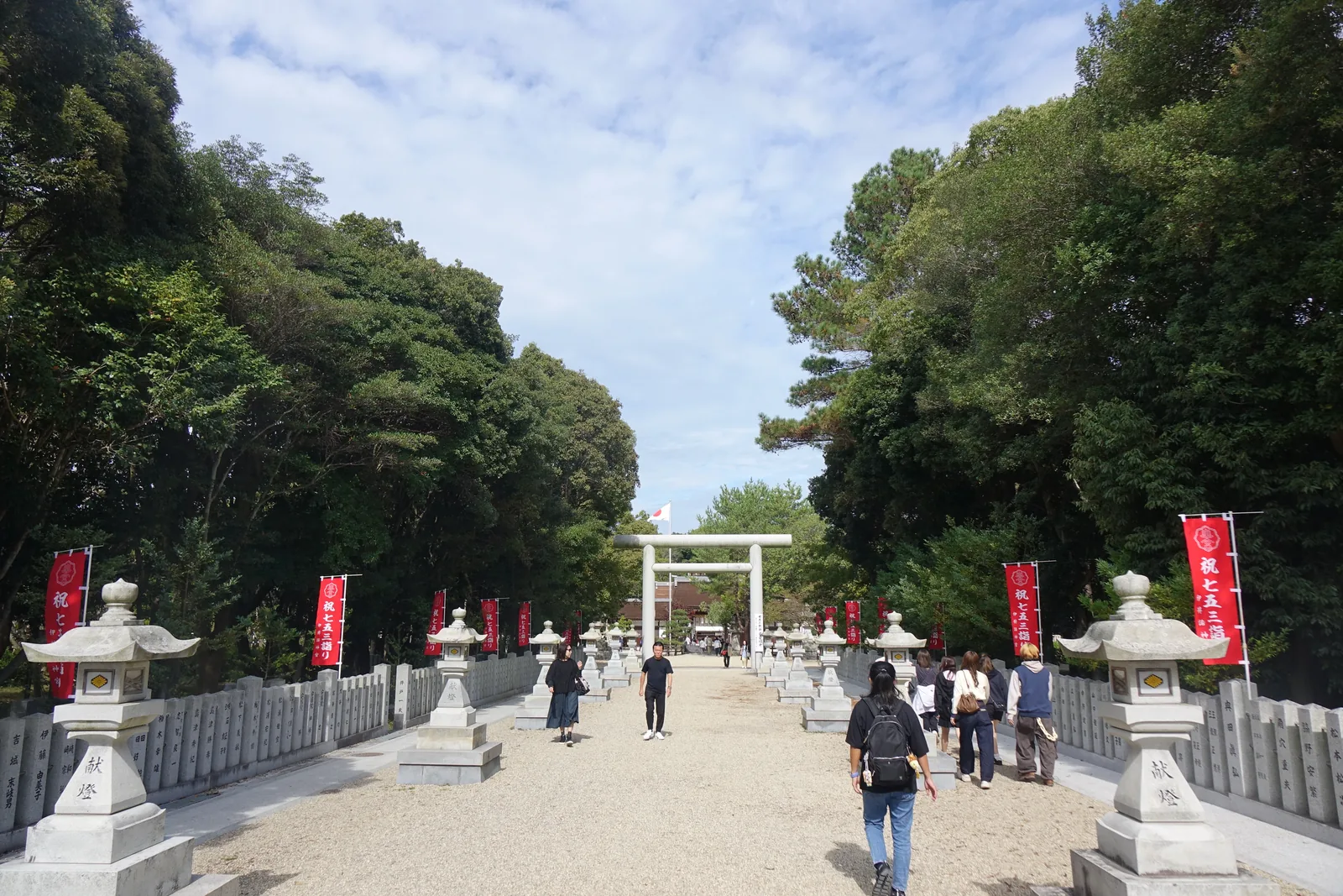 伊弉諾神宮的表參道，兩側石燈籠與紅幟，盡頭是花崗岩的大鳥居