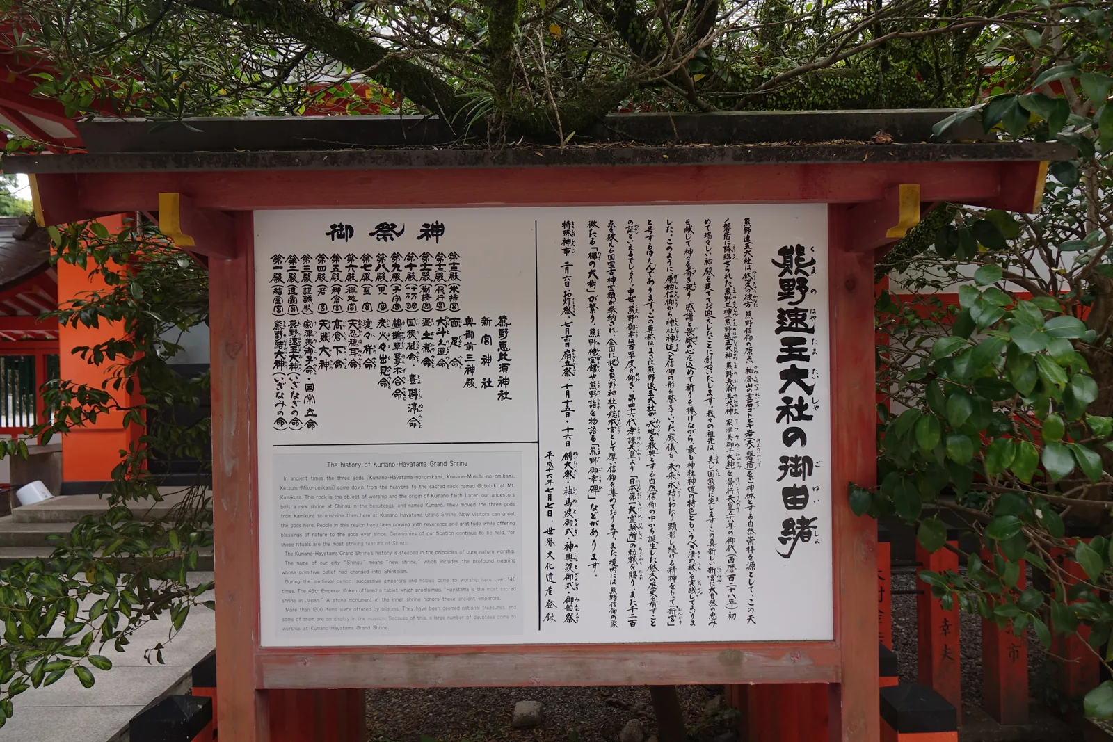 熊野速玉大社境內的日英對照由緒板，右半從神倉山的降臨寫到景行天皇五十八年築宮於此號「新宮」，左半列出十二殿的祭神