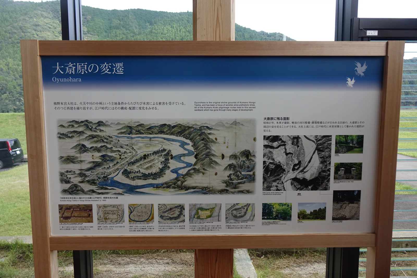 世界遺產熊野本宮館的「大斎原の変遷」展示板，第一句話寫著這座神社因為火災與河中洲這個立地條件而屢次受水害，右下角是昭和二十七年美軍拍的空照片
