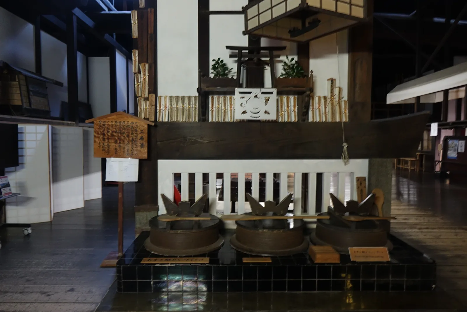 金剛峯寺台所裡並排的三座大釜，架在黑色的爐座上，柱梁被煤煙燻黑，正面供著三寶荒神