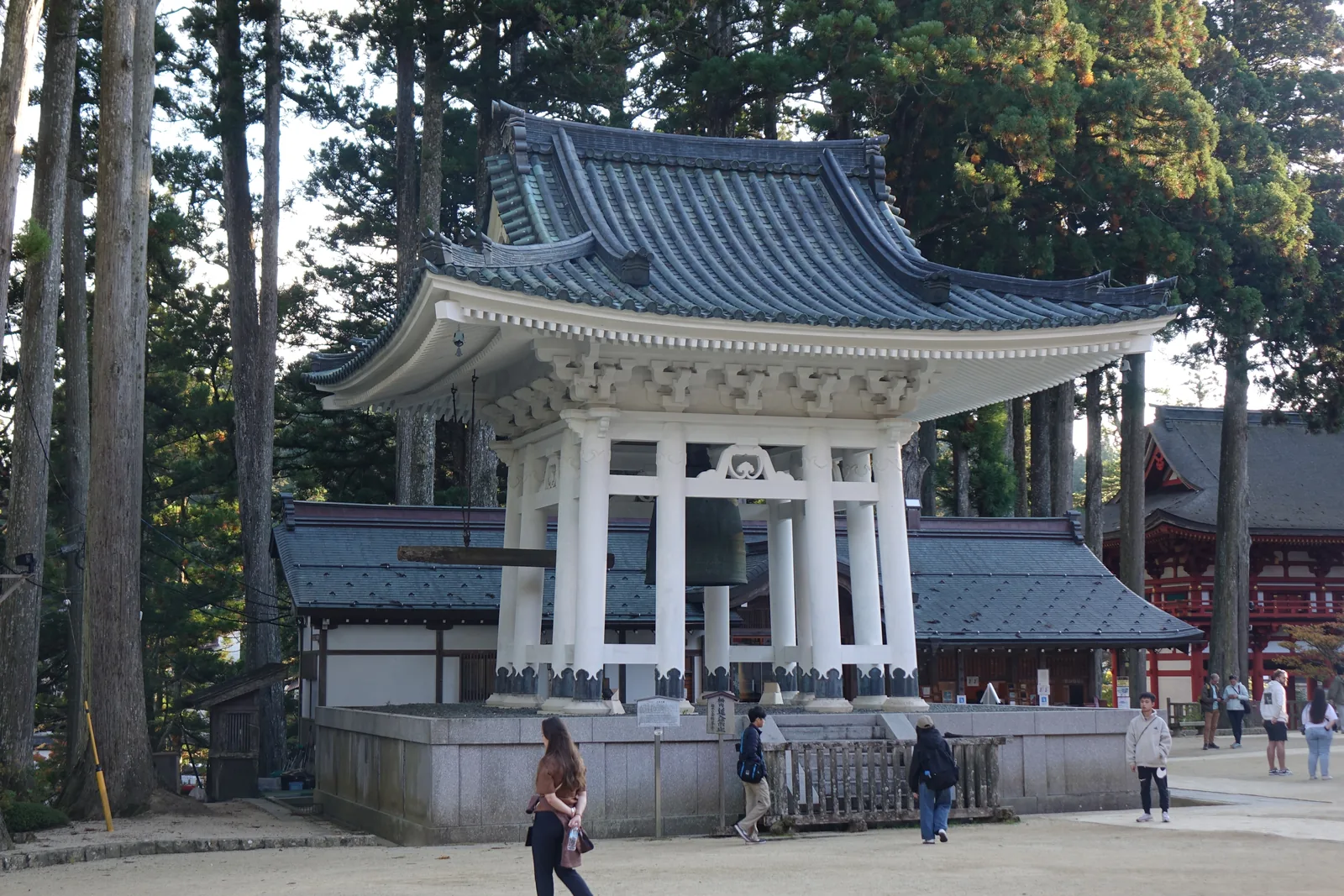 壇上伽藍的大塔之鐘「高野四郎」，白色的鐘樓架在石台上，銅鐘懸在中央，右緣露出朱紅的根本大塔