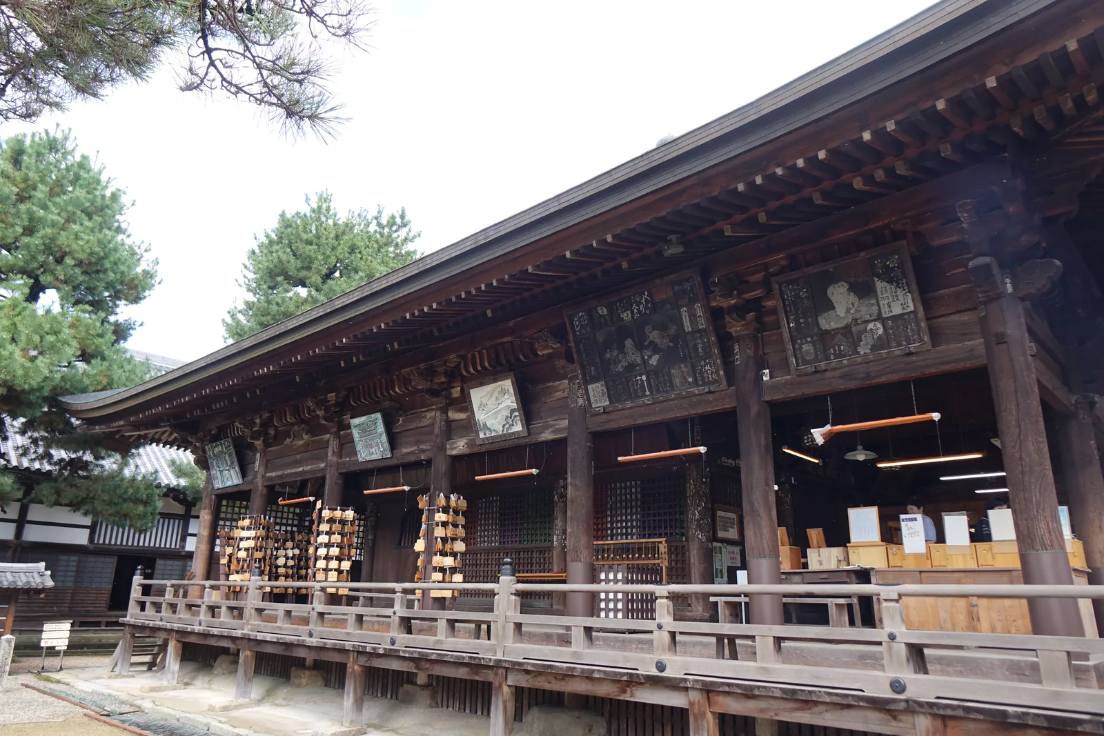 智恩寺文殊堂側面：帶寶珠高欄的緣繞著建築四周走，外牆從腰的高度到屋簷掛滿了木框的絵馬與額