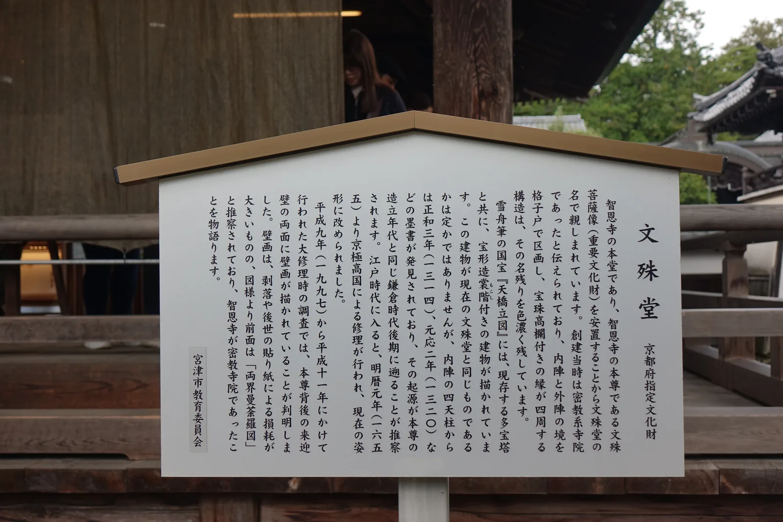 宮津市教育委員會設置的「文殊堂」說明板，白底黑字，標題旁註明京都府指定文化財