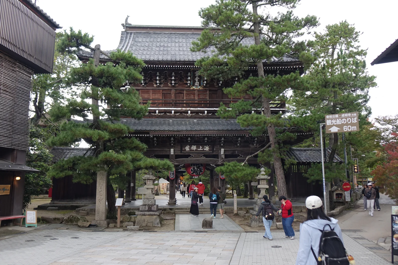 智恩寺的三門「黄金閣」正面：禪宗樣三間三戶二重門，下層扁額刻「海上禅叢」，上層是「黄金閣」，門前兩側是松