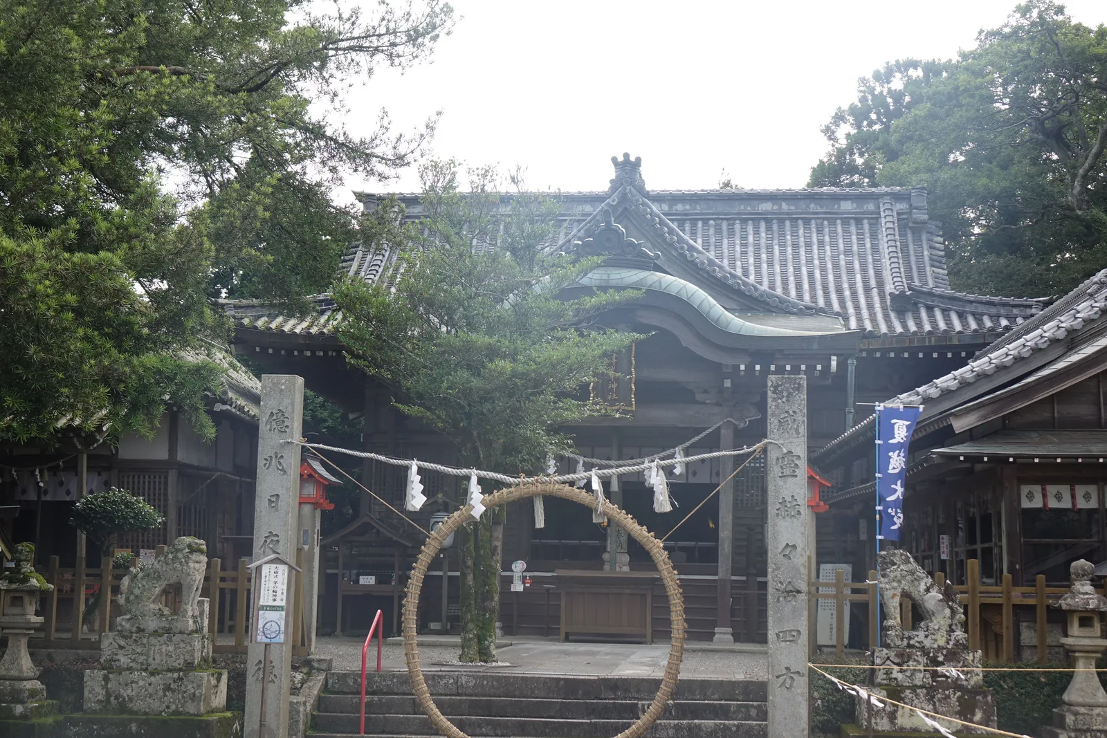 津峯神社拜殿前立著茅之輪：用茅草紮成的大草環立在石階前，兩側是石柱與注連繩，後方是拜殿
