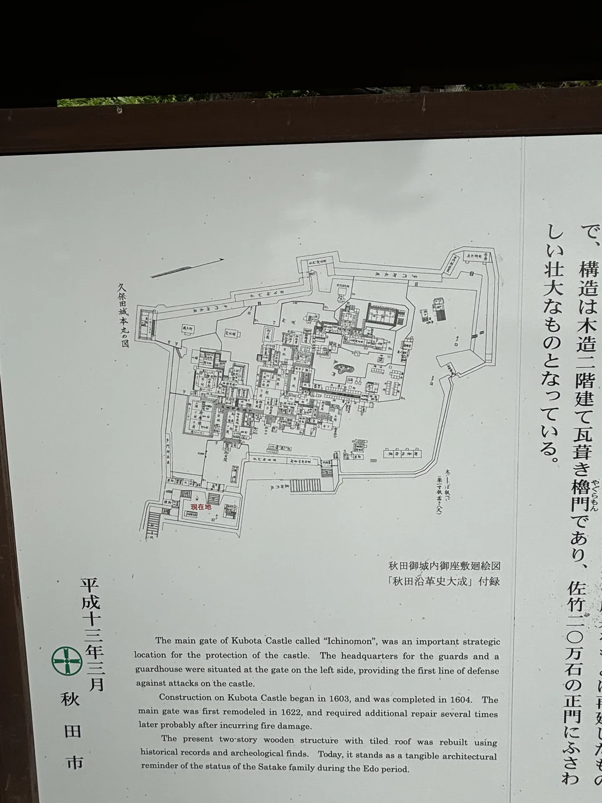 一面白底黑字的說明板，右半是直書的日文，左半是橫書的英文與一張城內配置的古圖（註明出自《秋田沿革史大成》附錄的「秋田御城内御座敷絵図」）。日文的末句寫這座門「佐竹二〇万石の正門にふさわしい壮大なもの」。板的左下角署「平成十三年三月　秋田市」。