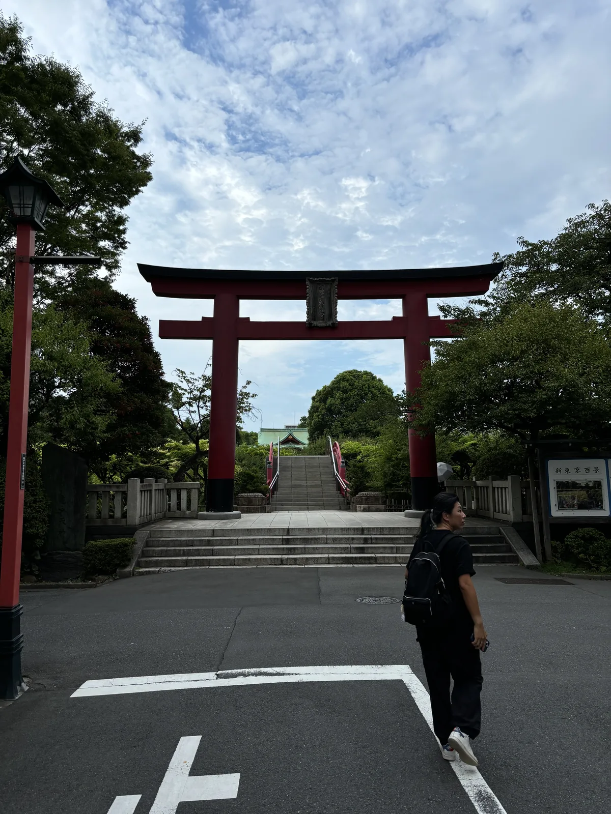 大鳥居的正面遠景。腳下是馬路的白色停止線，鳥居直接立在街邊，沒有前庭，也沒有參道的緩衝。