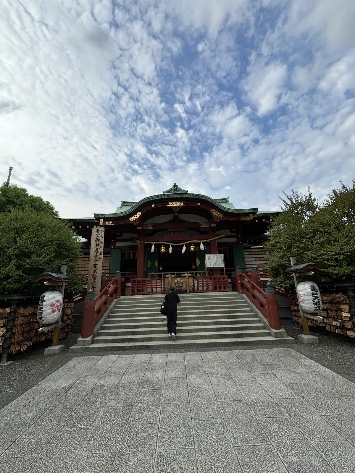 正面近景。注連繩與紙垂橫過向拜，左右垂下提燈，石階兩側立著石燈籠。屋頂是覆銅板，已經氧化成均勻的綠青色。