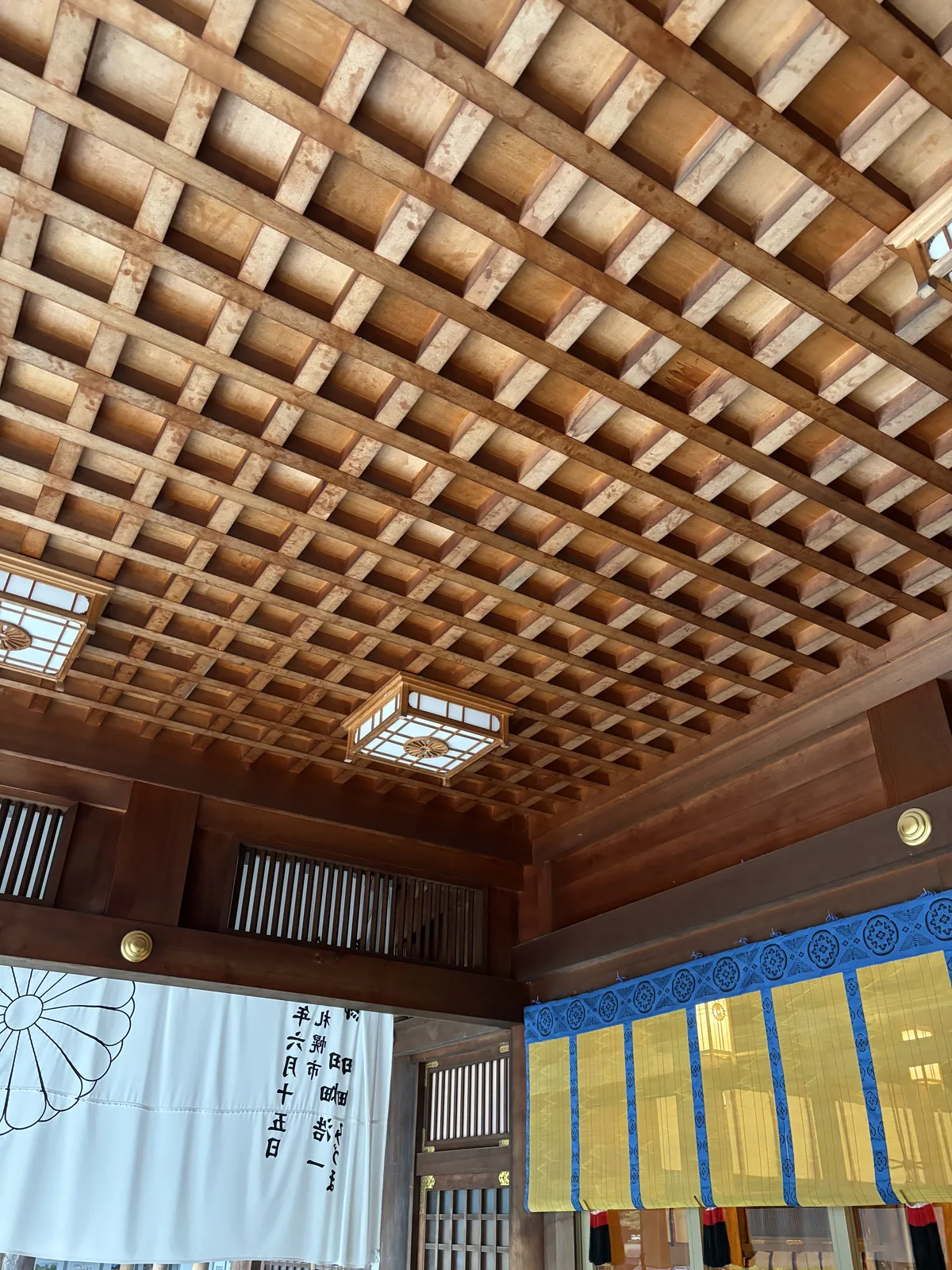 北海道神宮拜殿內部的格天井，木格一路排到深處，一盞方形吊燈籠垂在中央