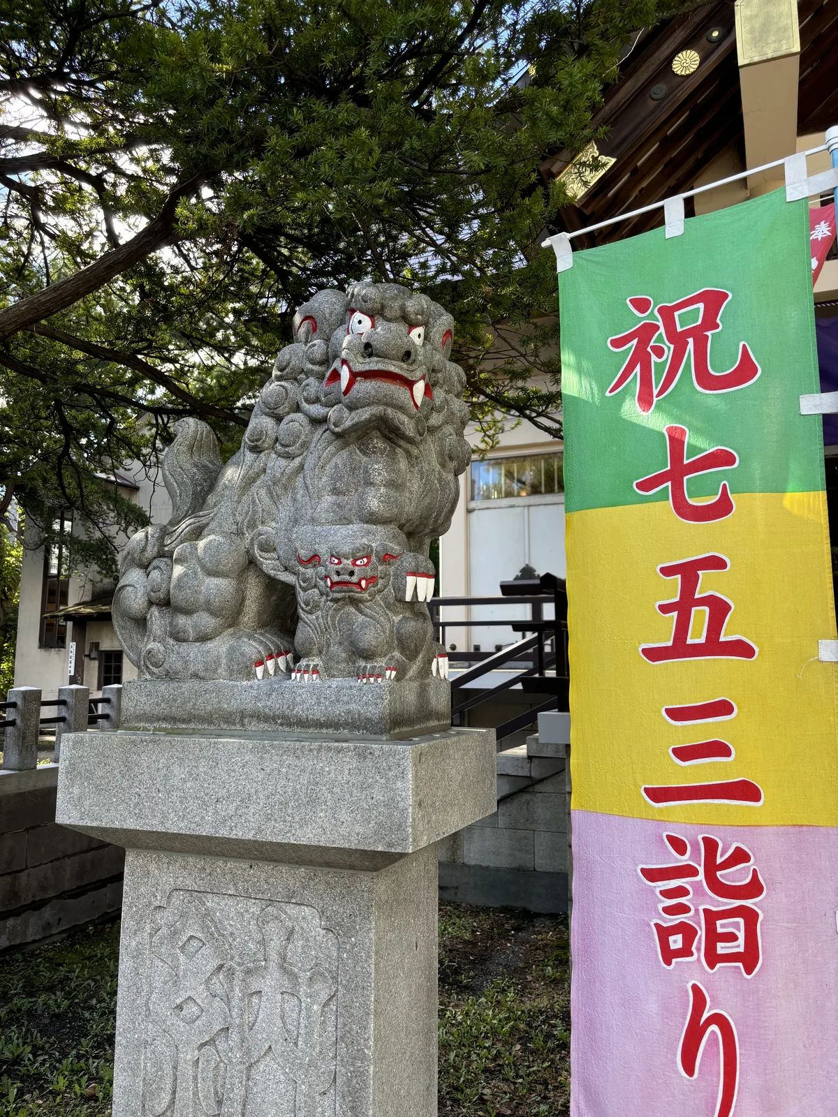 豐平神社的另一尊狛犬，身邊蹲著一隻小獅，右側是「祝七五三詣り」的彩色幟
