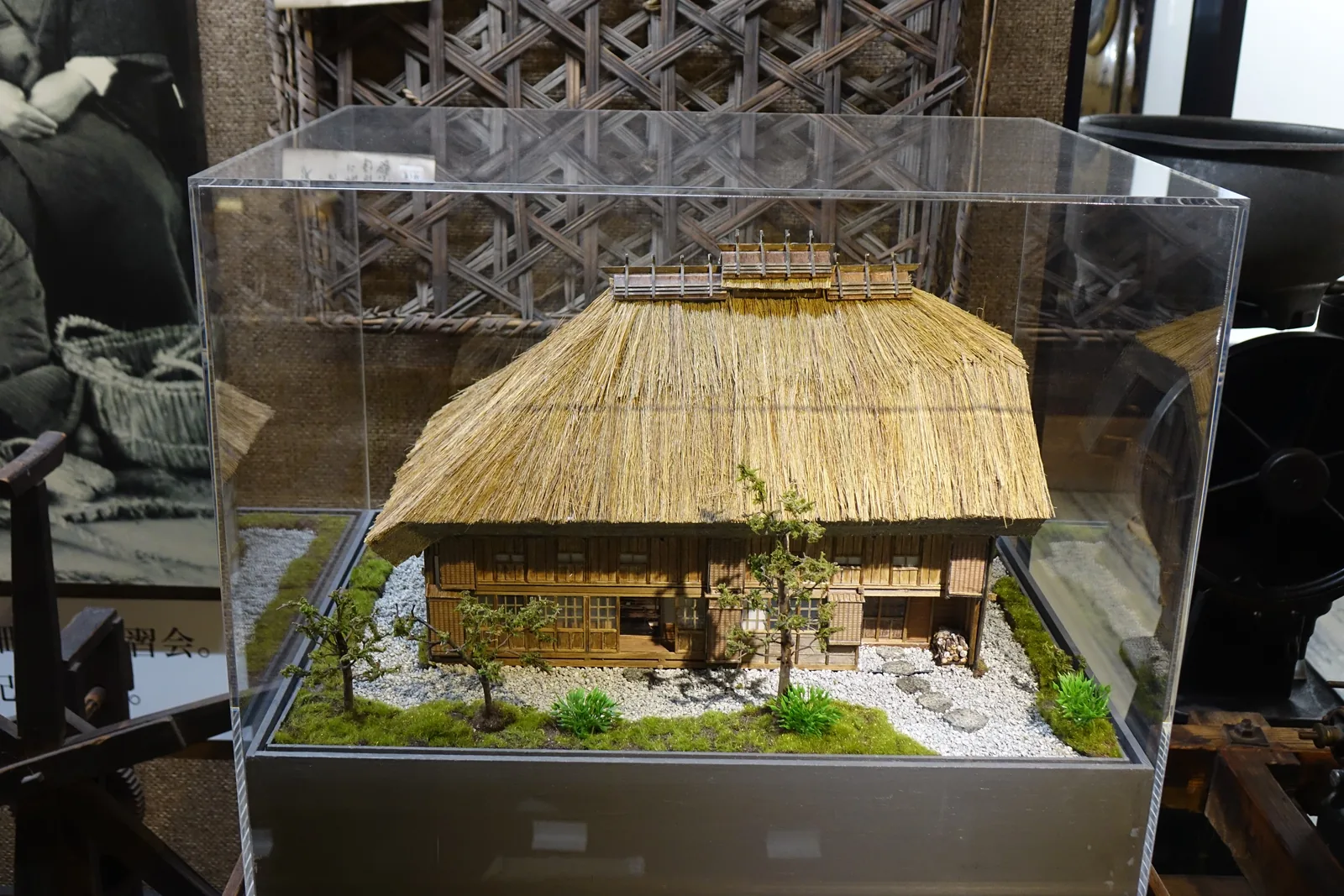 旭川兵村記念館展示的屯田兵屋模型，茅葺屋頂厚而低，正面開連續的木格窗與緣側
