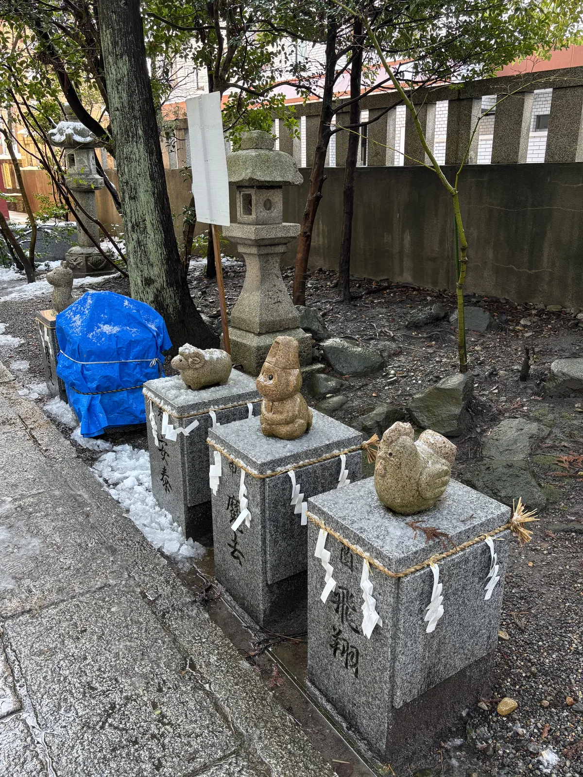 麁香神社參道旁的干支石像，花崗岩方座上各坐一尊生肖，四邊圍著注連繩與紙垂