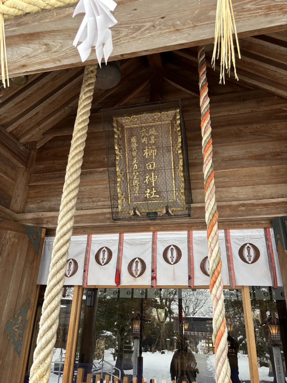 櫛田神社拜殿的扁額，外罩鐵絲網，金泥陰刻「延喜式内　櫛田神社」，左側落款「國務大臣　正力松太郎謹書」