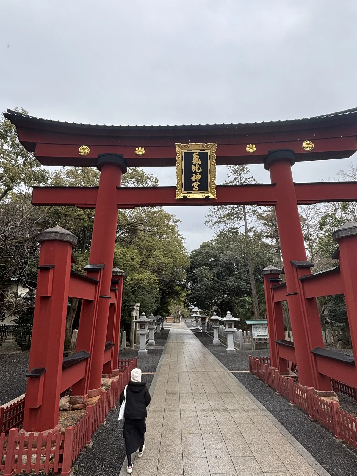 氣比神宮大鳥居正面仰視，朱漆的柱身與黑色笠木，額束上掛著黑地金框的扁額