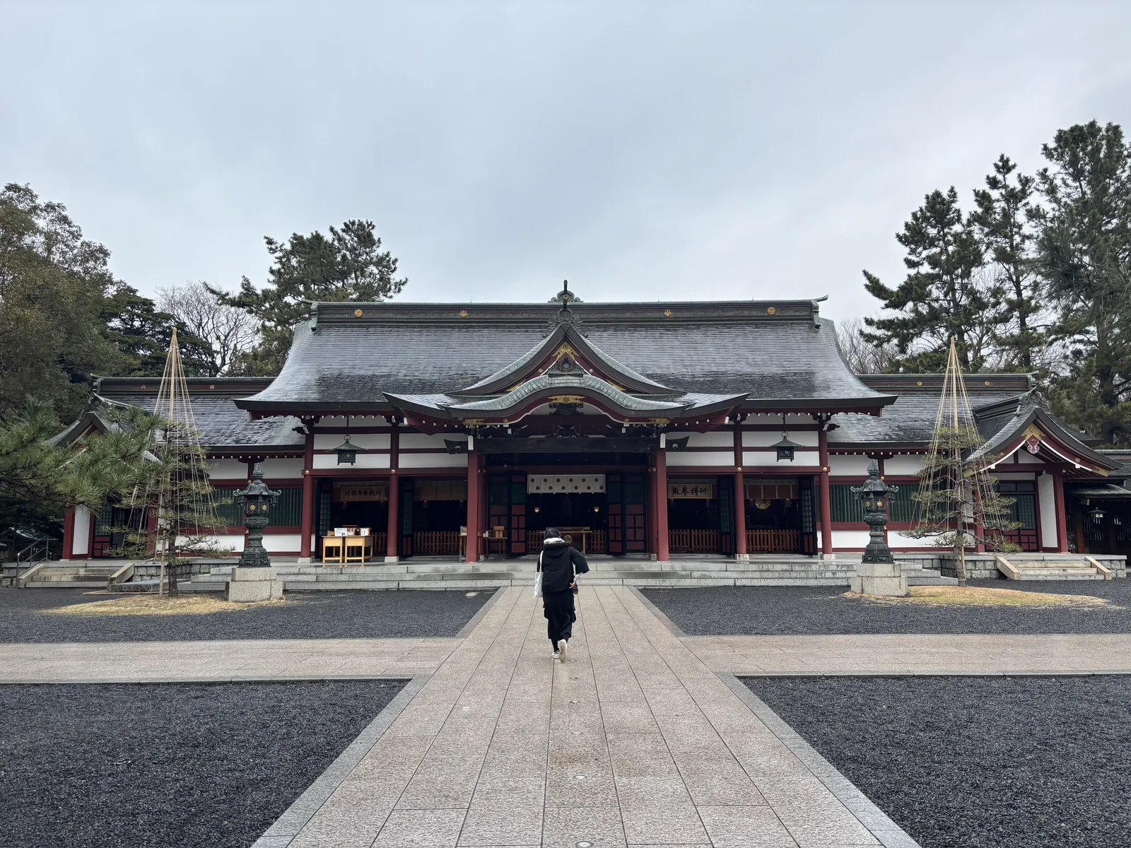 從中鳥居往內看氣比神宮外拜殿全景，左右伸出迴廊，前庭一半鋪石一半玉砂利