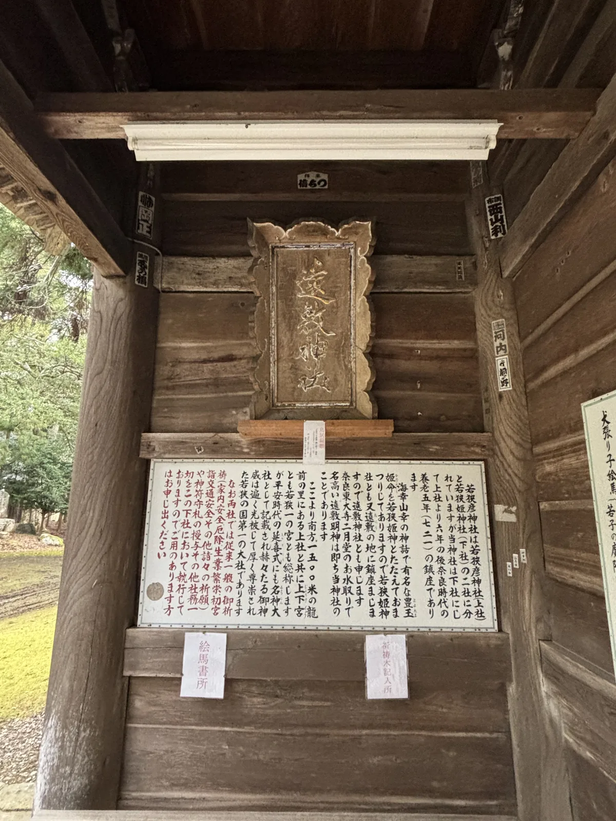 若狹姬神社拜所內側，木彫金彩的扁額寫著「遠敷神社」，下方是由緒掲示