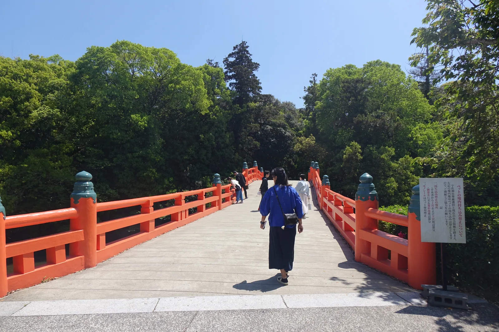 朱紅的神橋橫過寄藻川，橋面兩側有欄杆，遠處是樹林