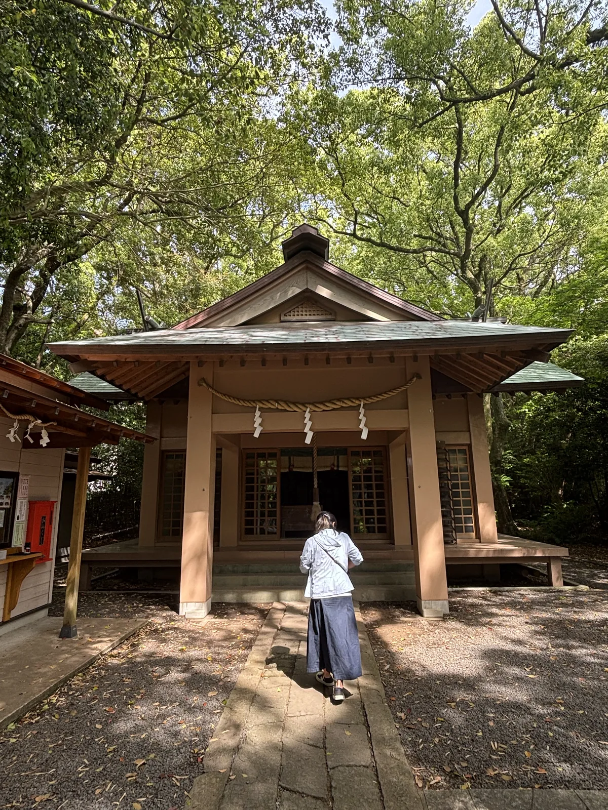 社殿正面，木造小型社殿，簷下橫一條注連繩、垂三束紙垂，左側是神札授与所