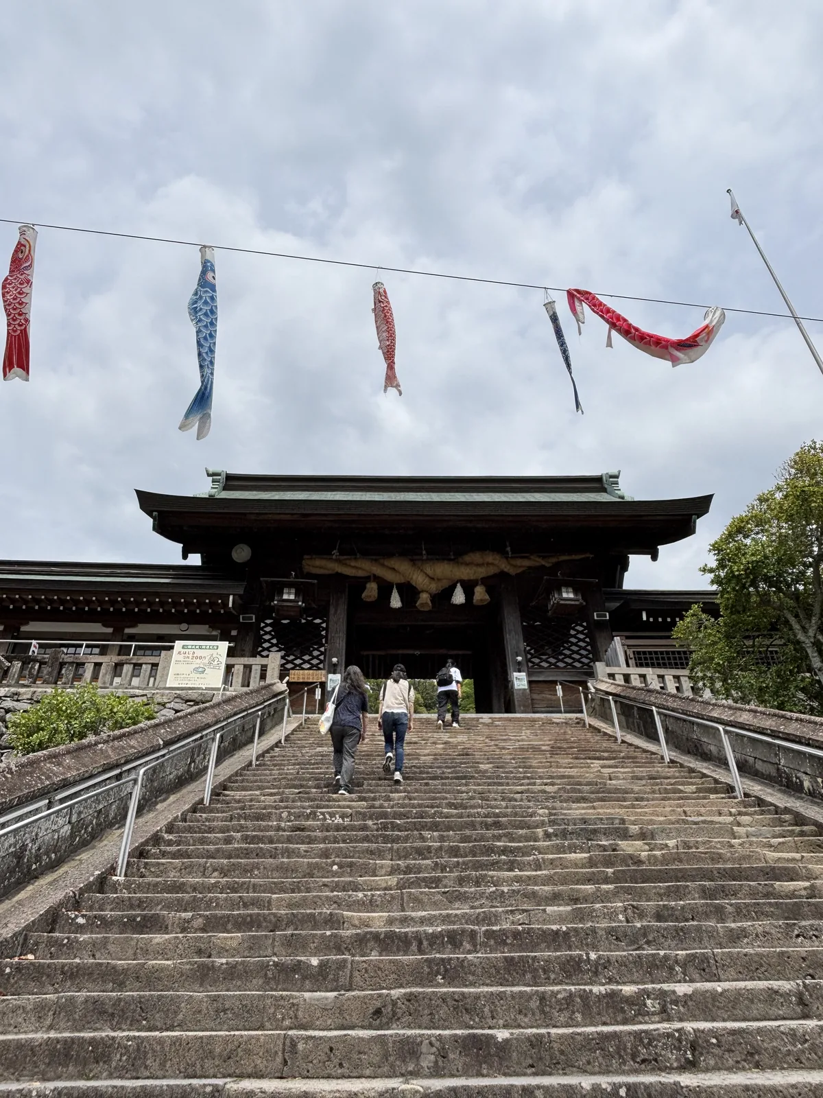 諏訪神社的長石階與大門，天空橫拉的繩子上掛著五隻鯉幟，大門下垂著注連繩